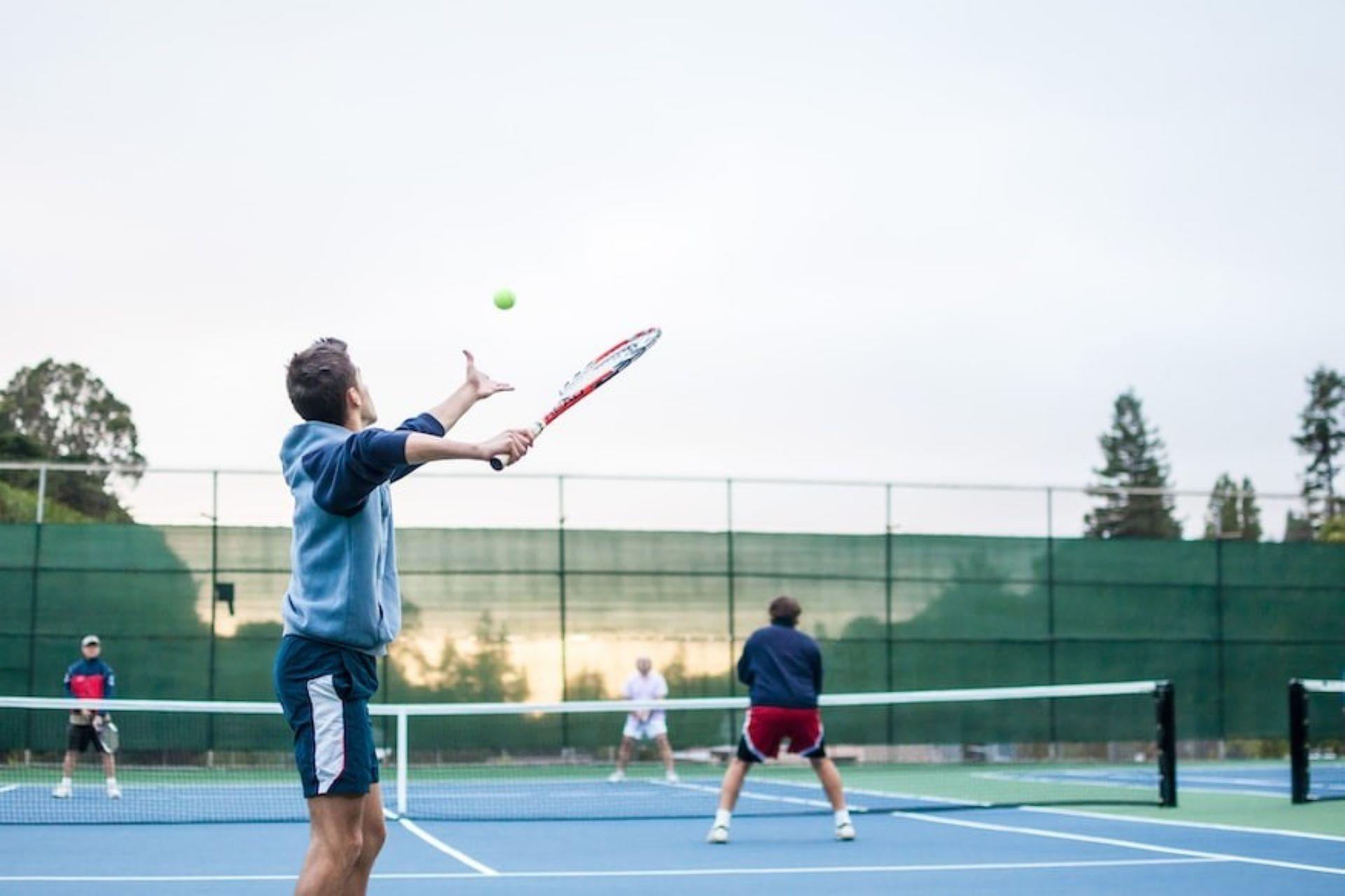 Four tennis players are playing a doubles match