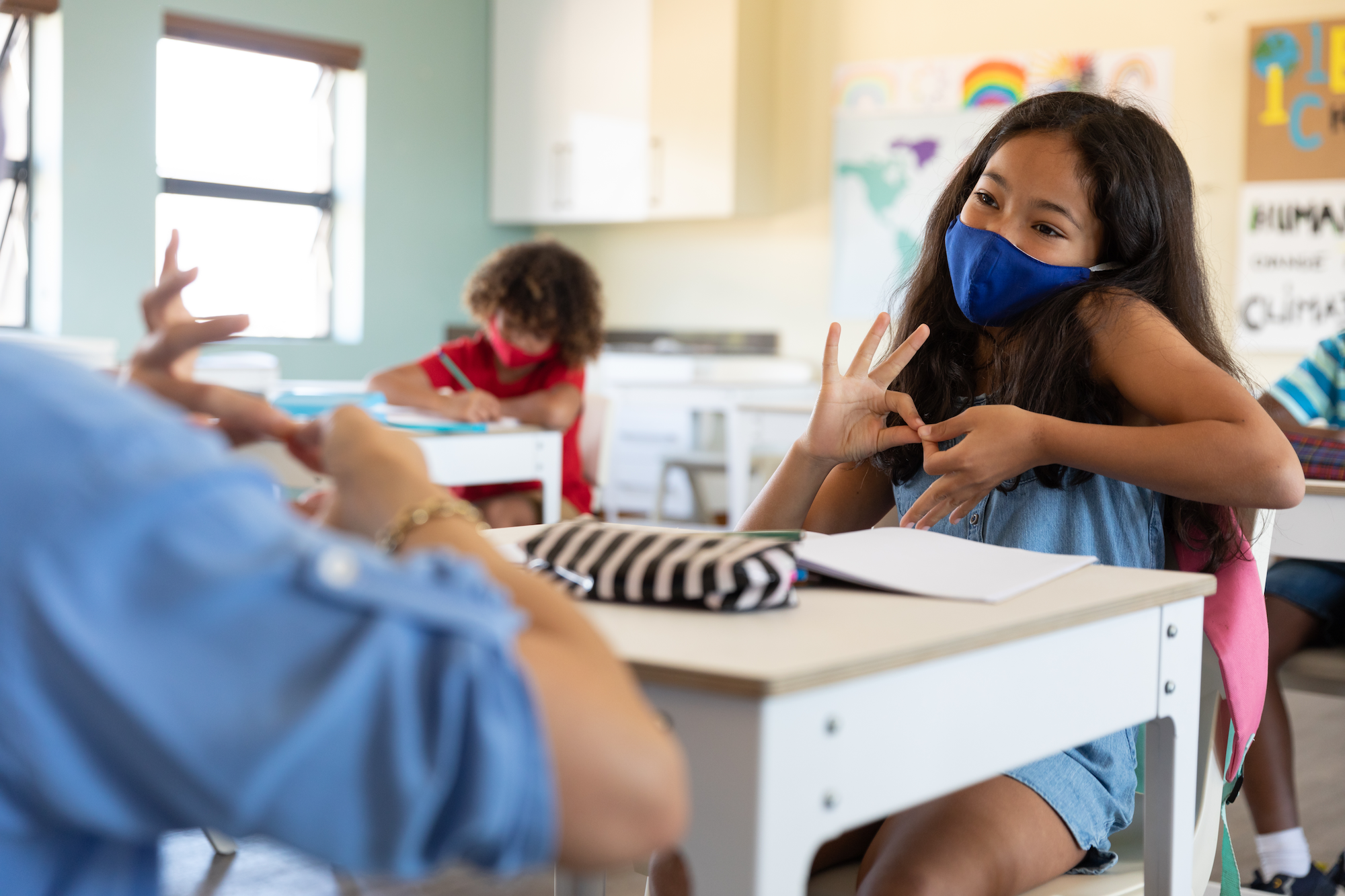 girl using sign language in class