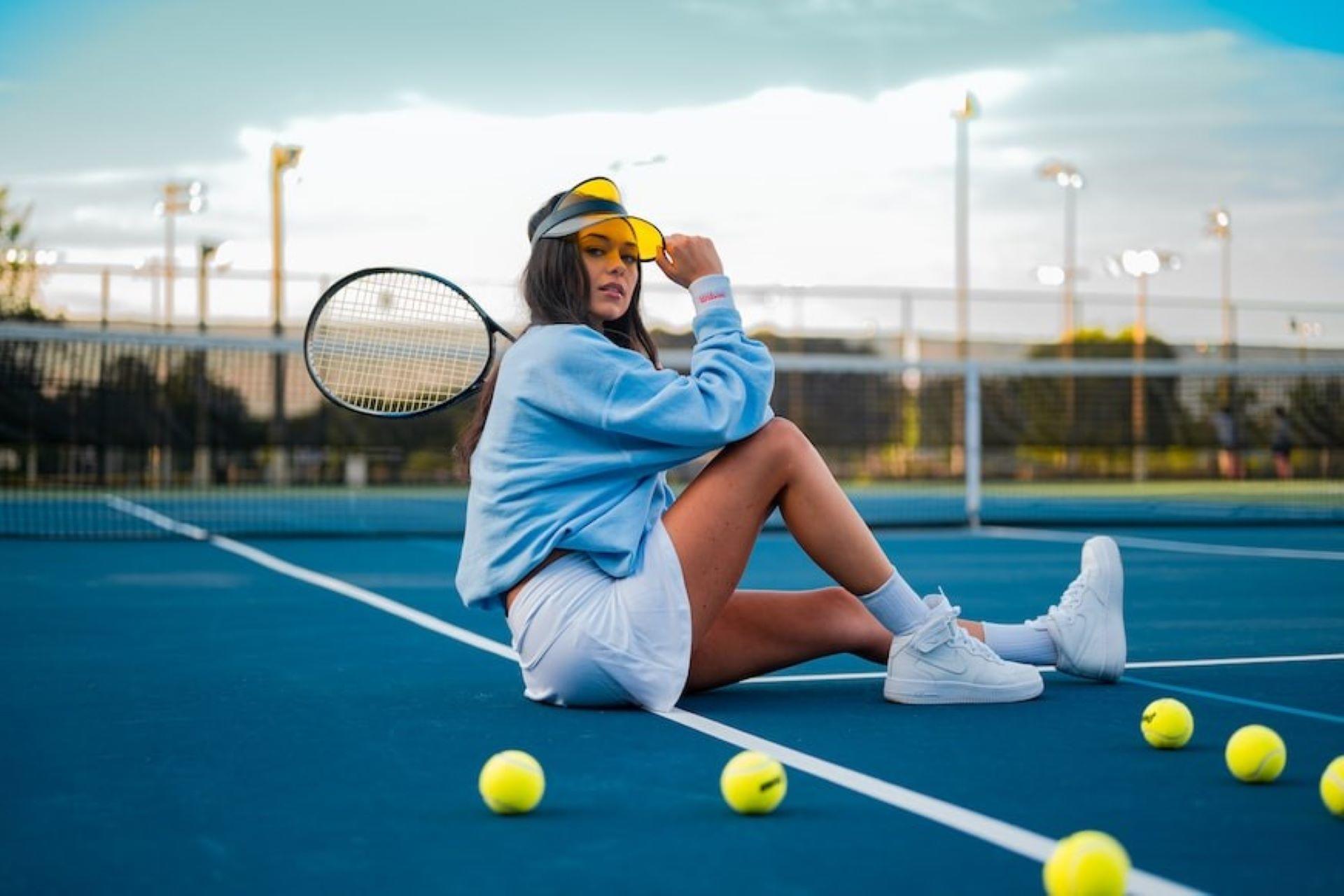 A girl sitting on a tennis court