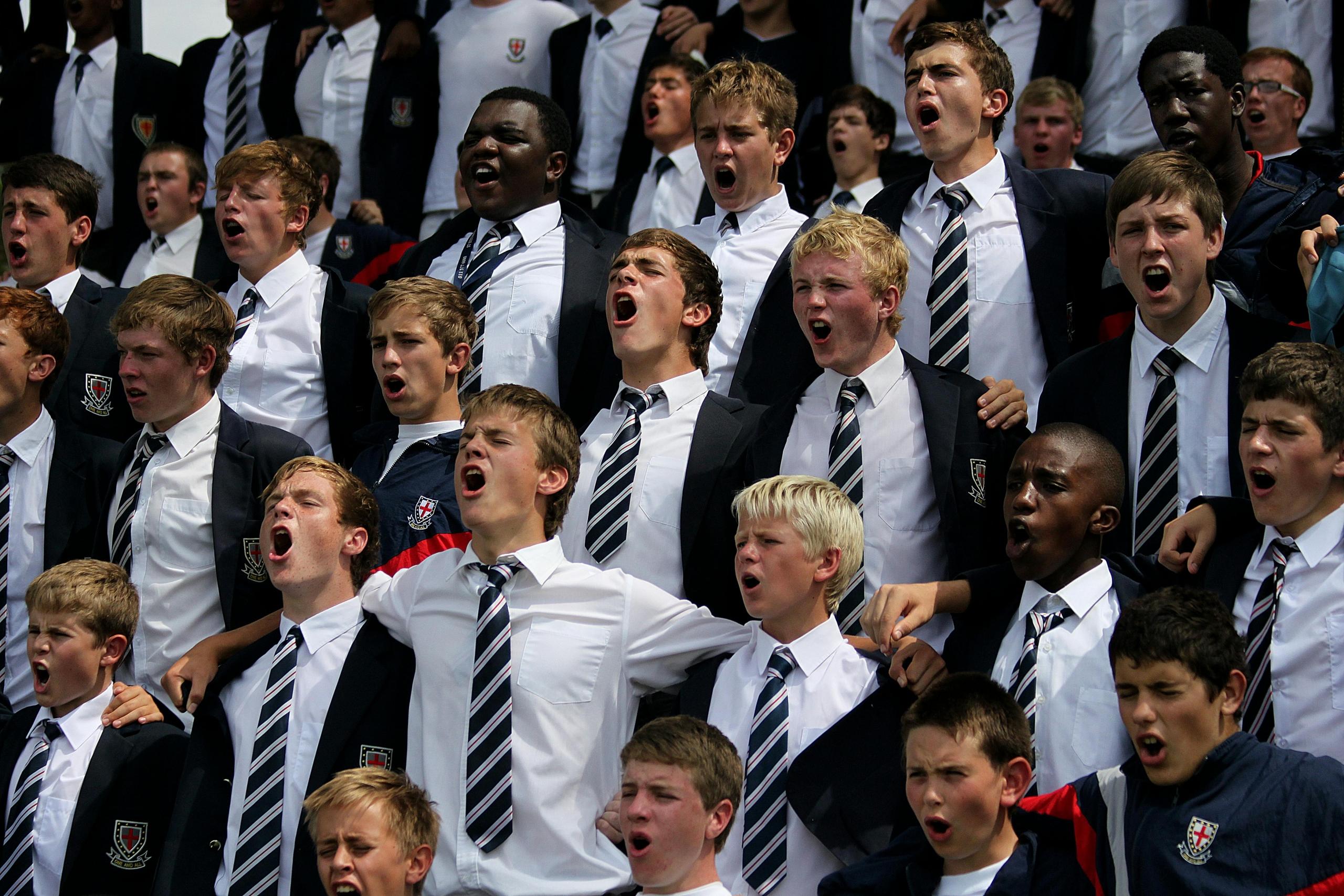 Rows of students dressed in uniform supporting their school's sports team