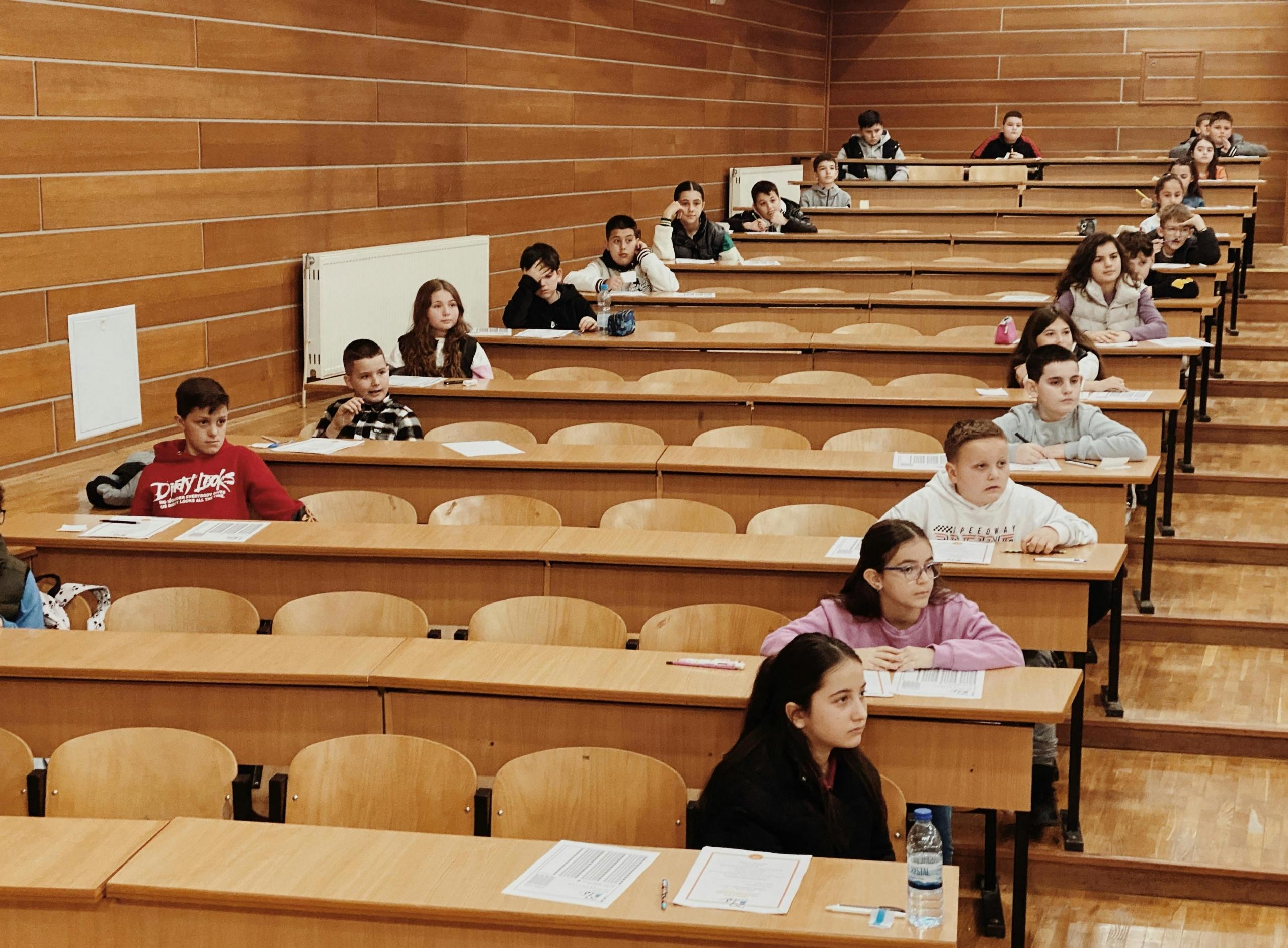 Students spaced out in a lecture hall ready to sit their entrance exams