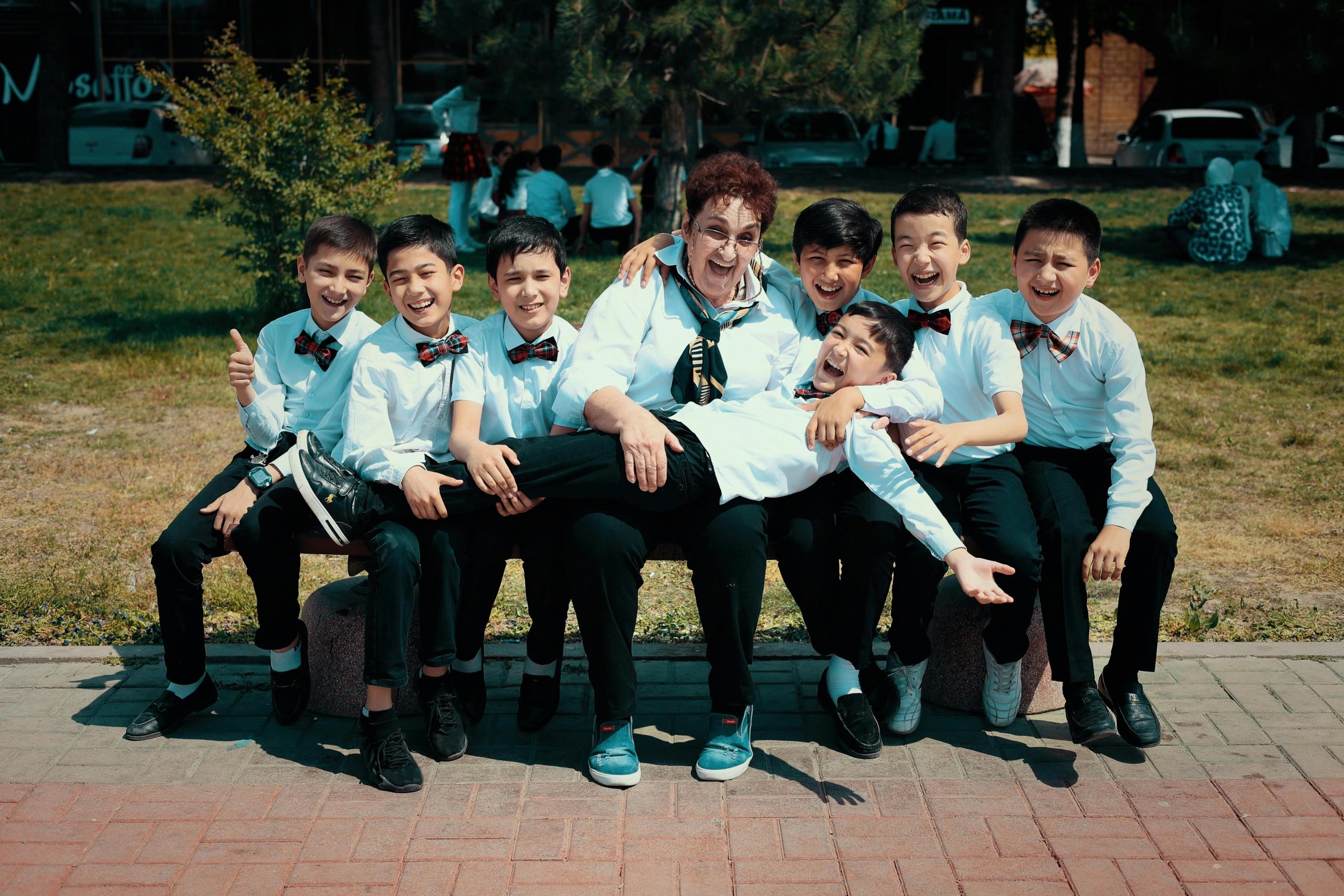 A group of students dressed in shcool uniform playing together in the yeard