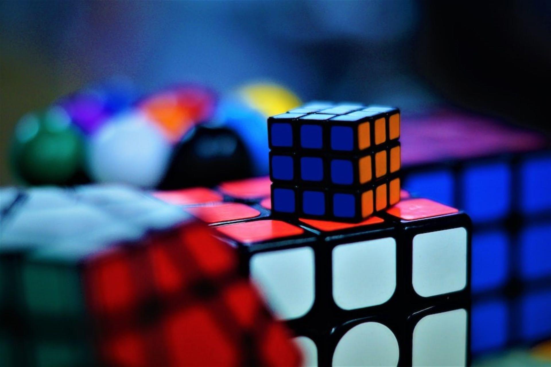 A mini Rubik's Cube on top of a full-sized one.