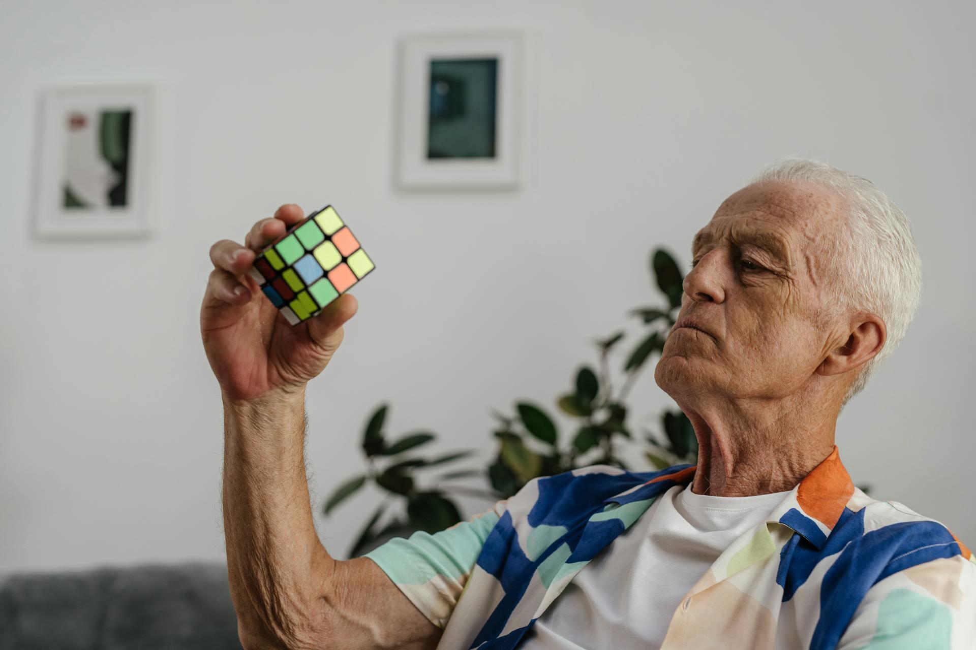 an elderly person holding a rubik's cube