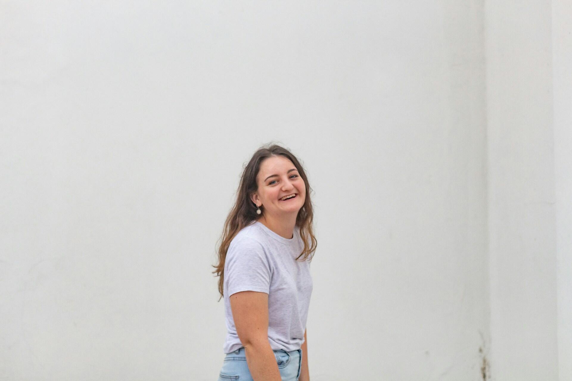 A woman wearing a white top smiling.