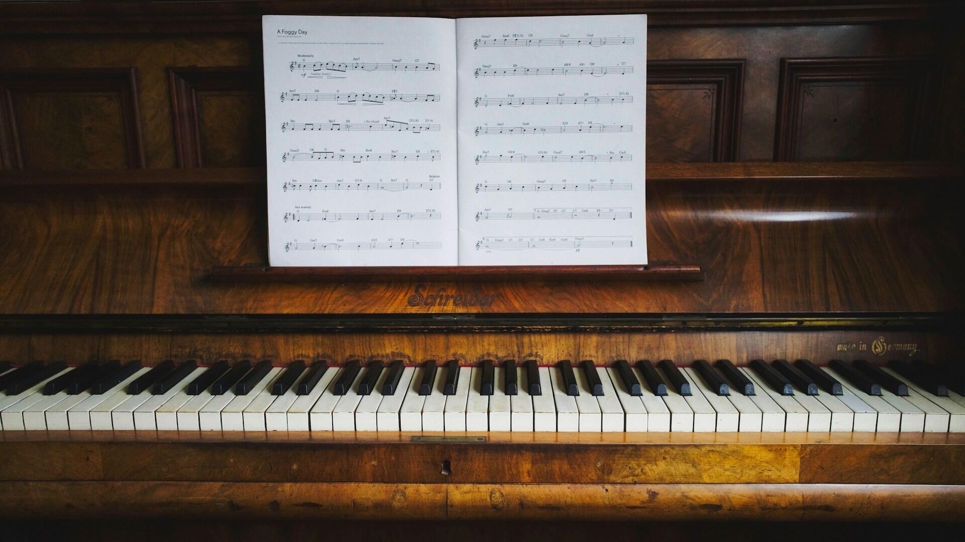 piano with sheet music resting on the top