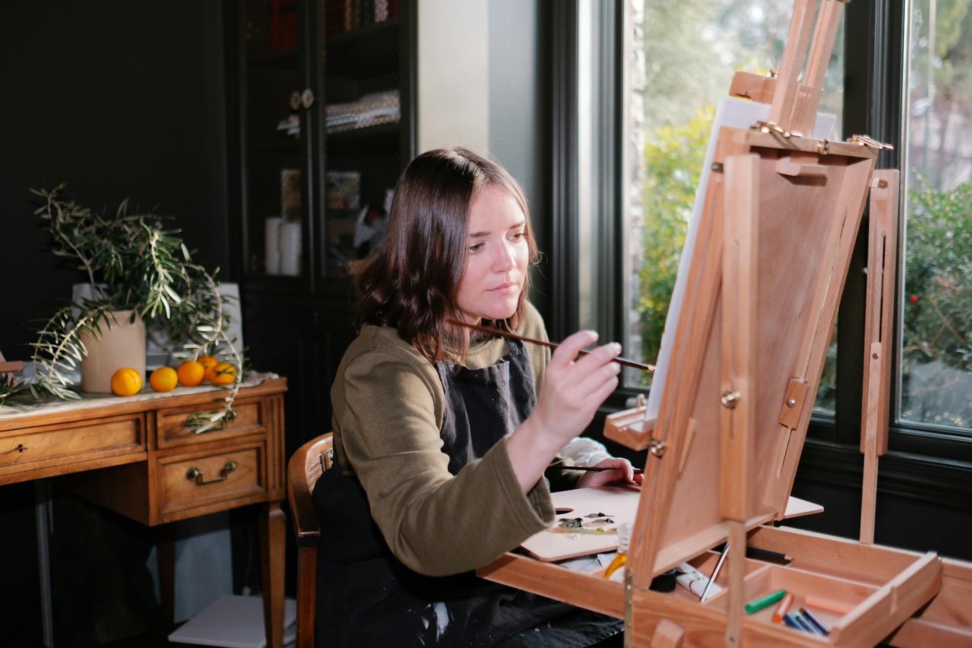 woman painting in an arts studio using an easel