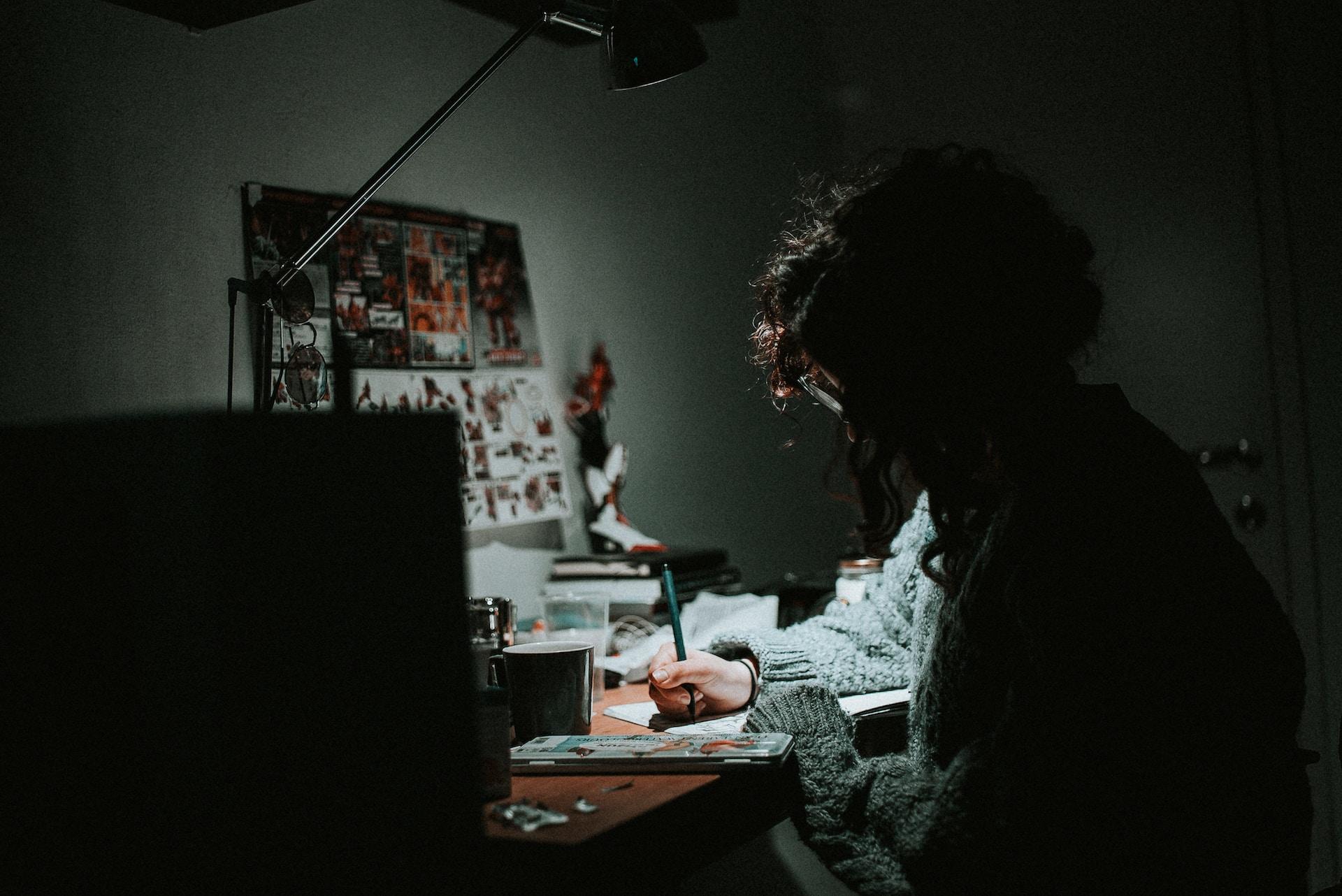 An artist drawing at a desk.