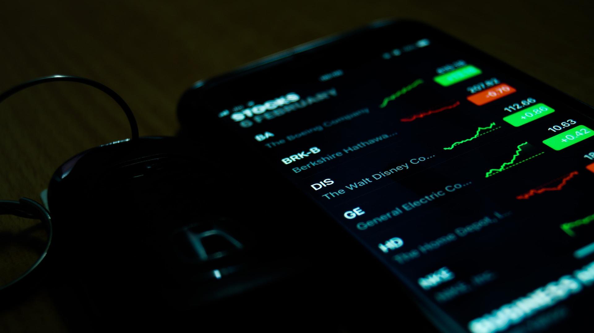 A smartphone displaying various stocks' performances in red and green.