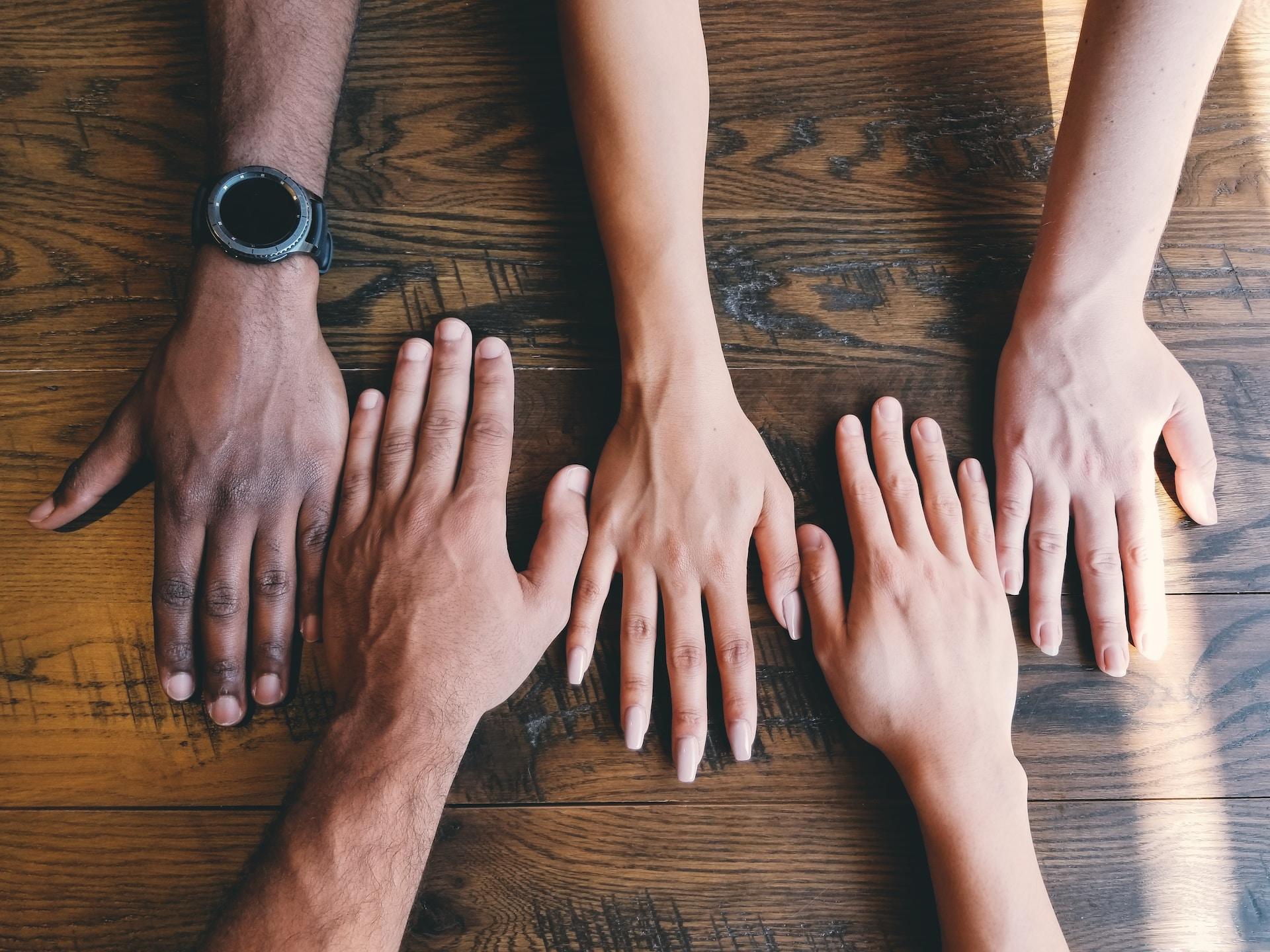 Five hands, each one of a different skin tone, to represent the five BRICS nations.