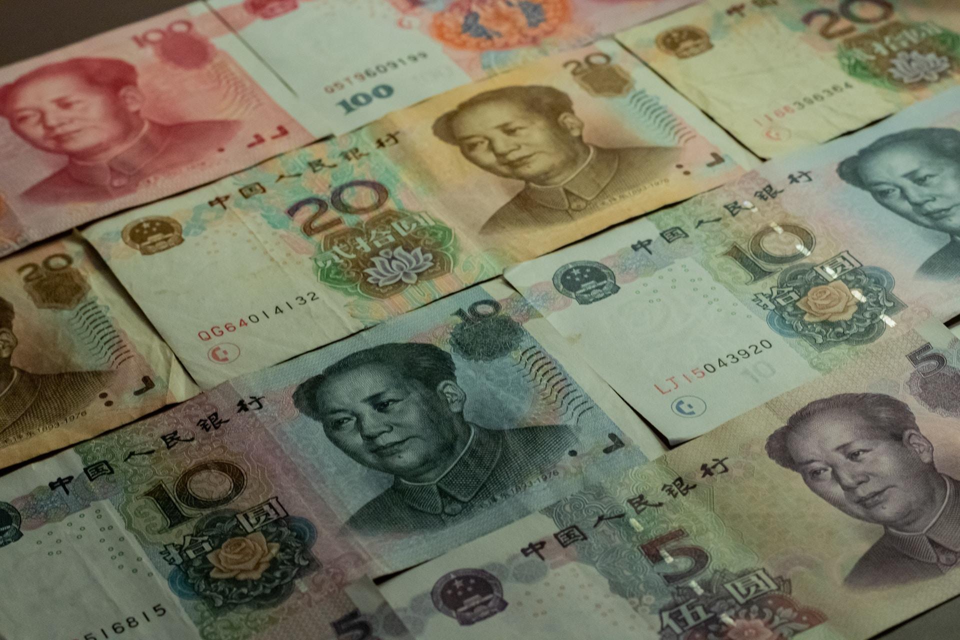 Rows of pink 100, brown, 20, blue 10 and purple 5 yuan notes laid end to end.