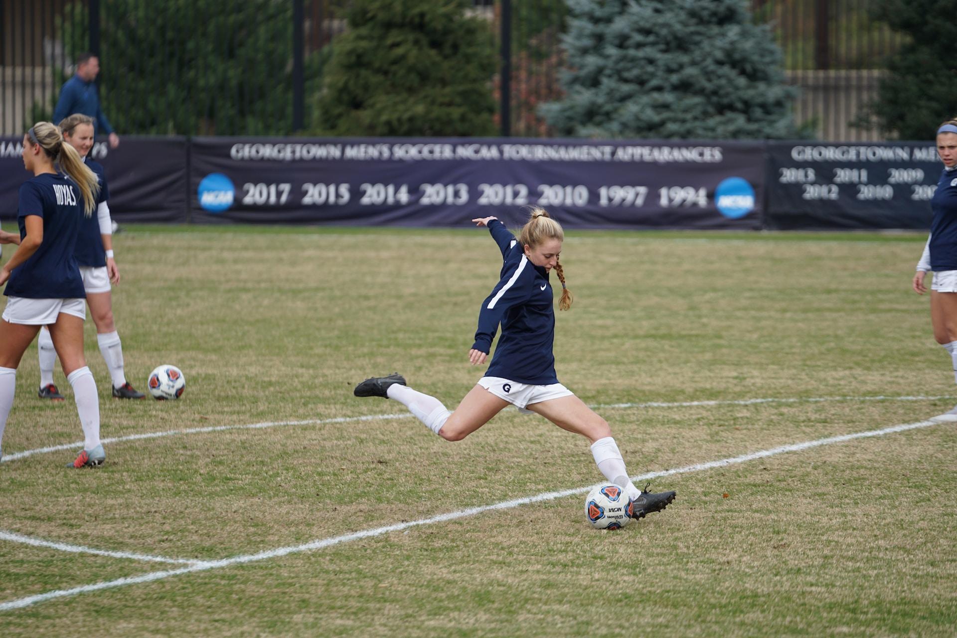 A female soccer player kicking a ball during a training session.
