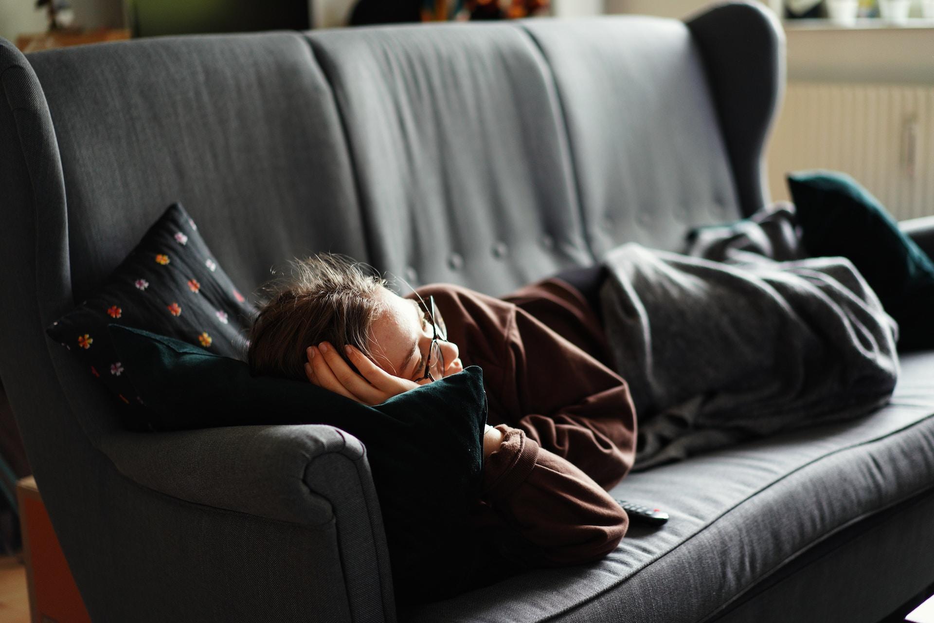 A person lying down on a couch.