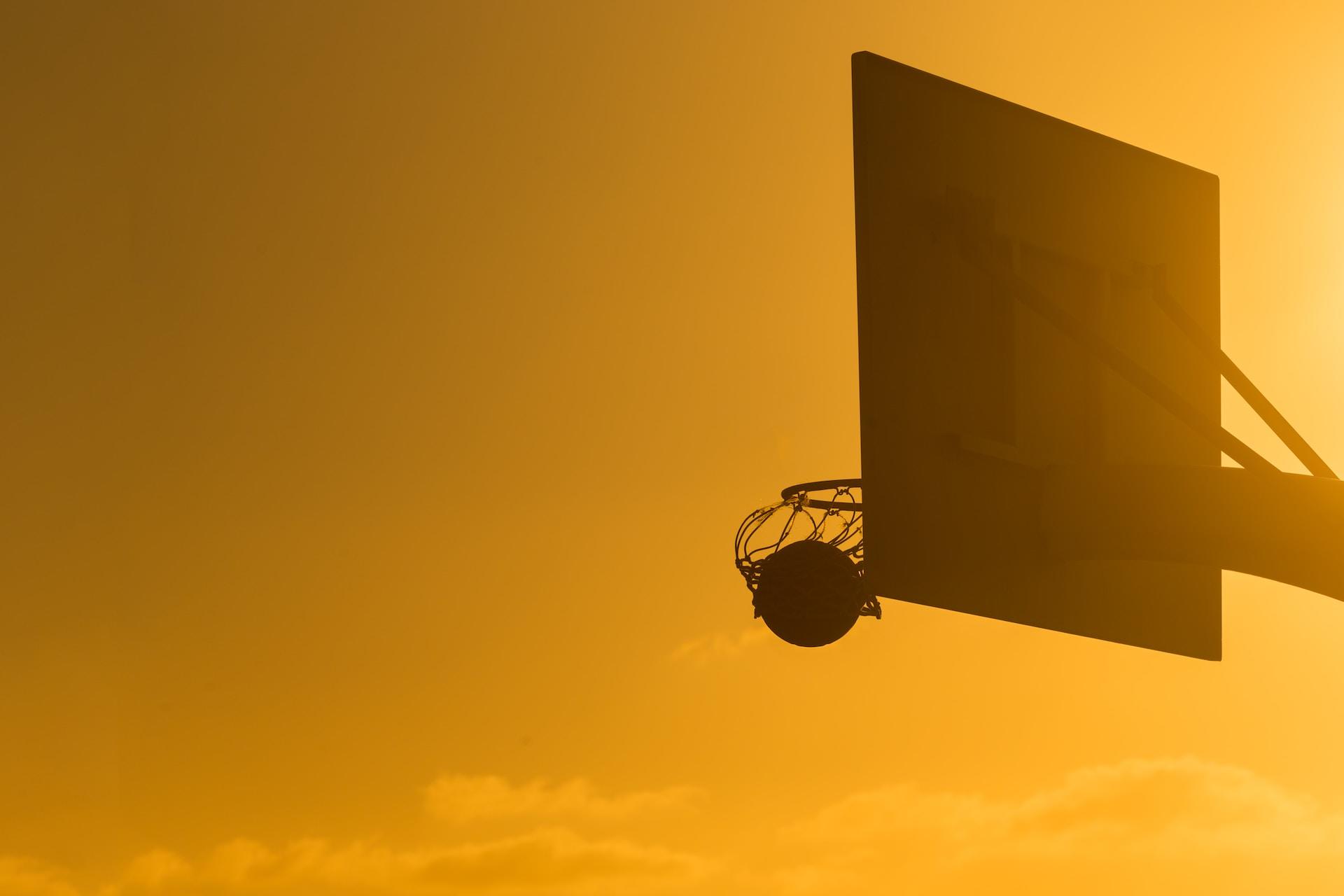 A basketball net at sunset.