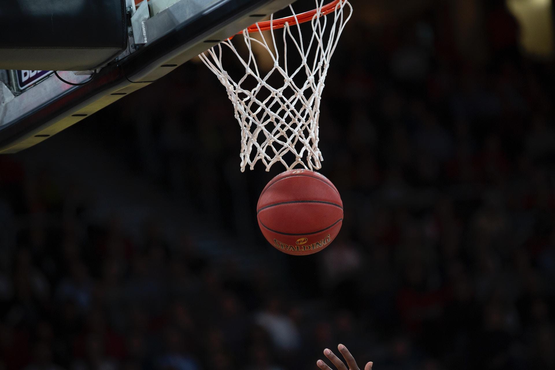 A basketball going through a net.