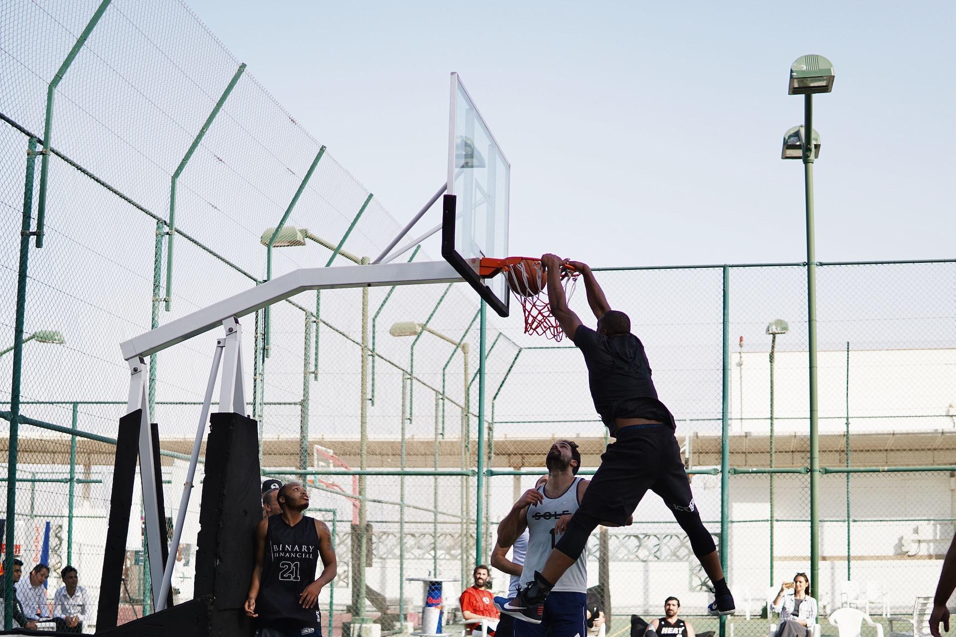 A basketball player dunking.