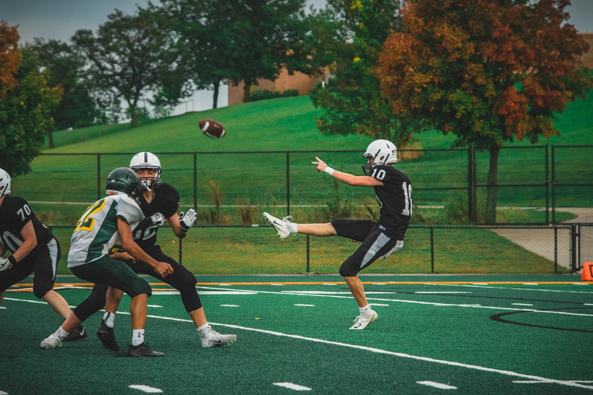 Football player about to punt the ball.