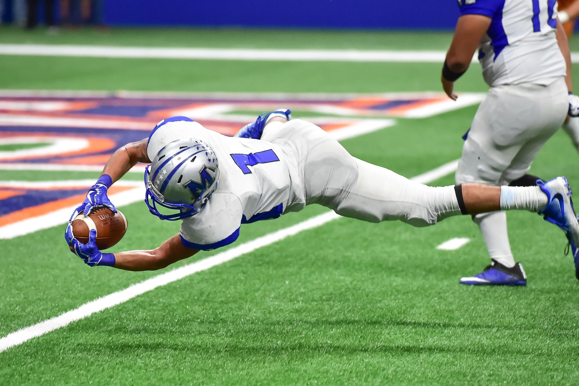 Football player reaching for a touchdown
