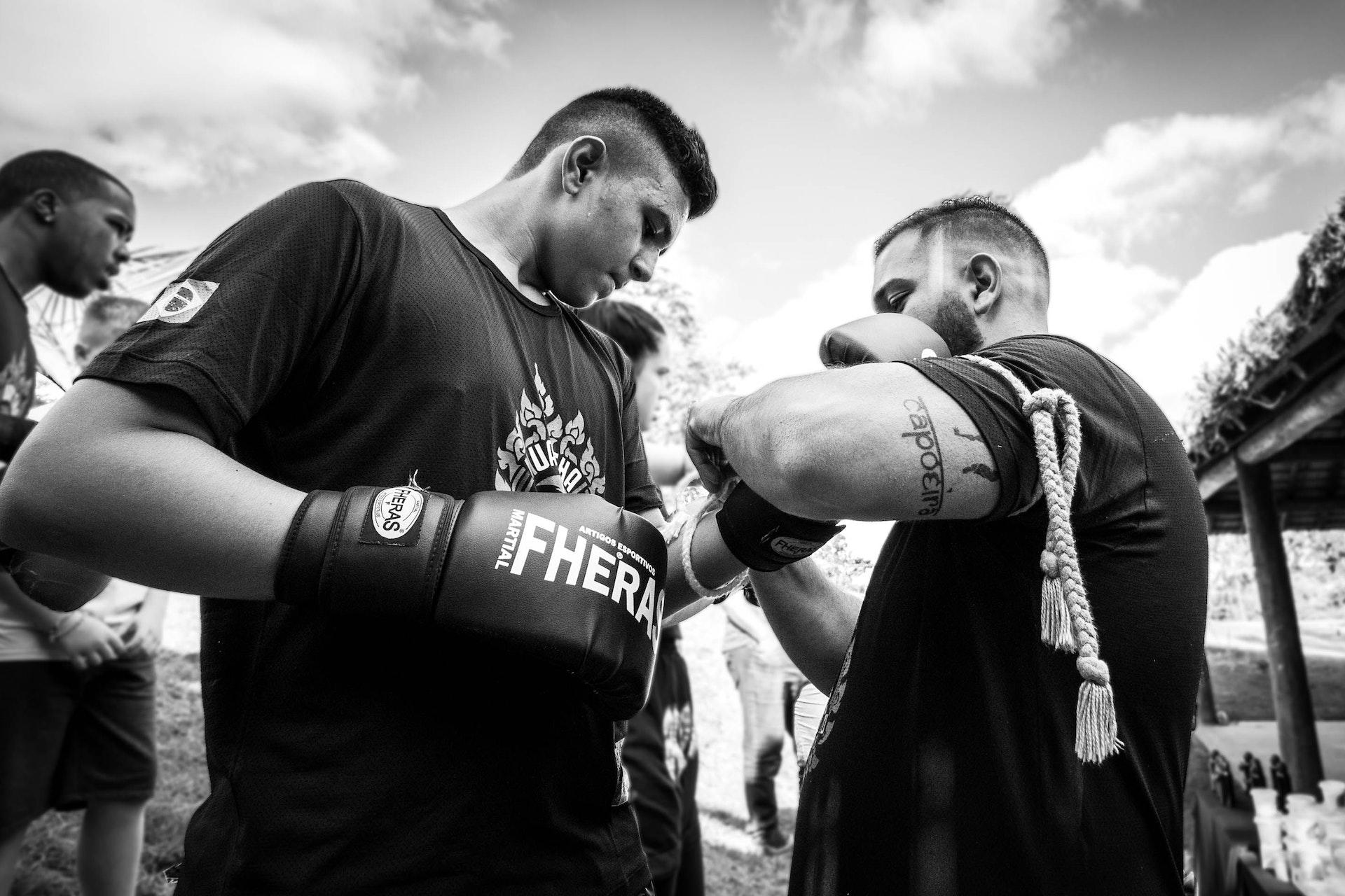Man tying gloves of a boxer.