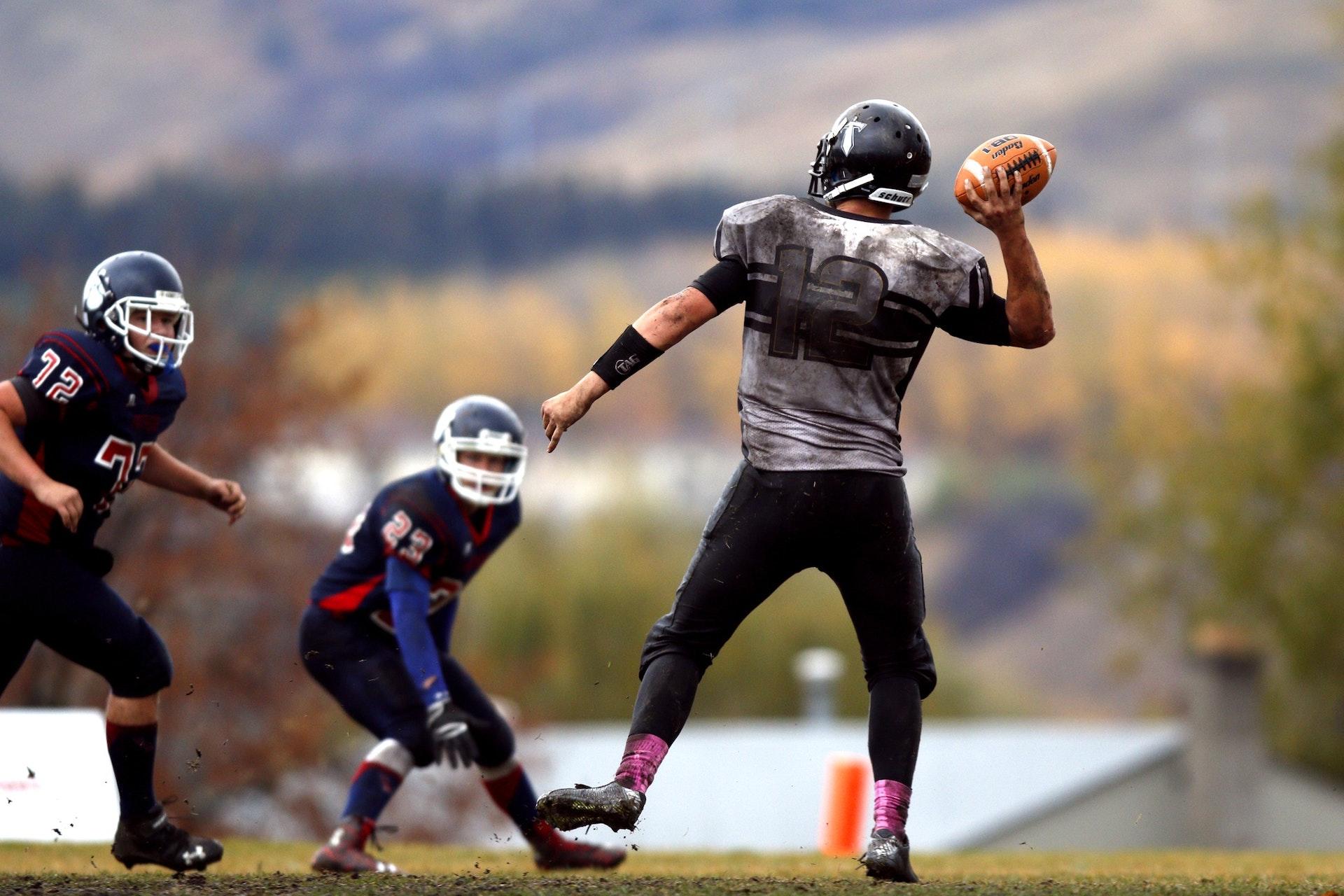 Two football players chase the ball in the stadium.