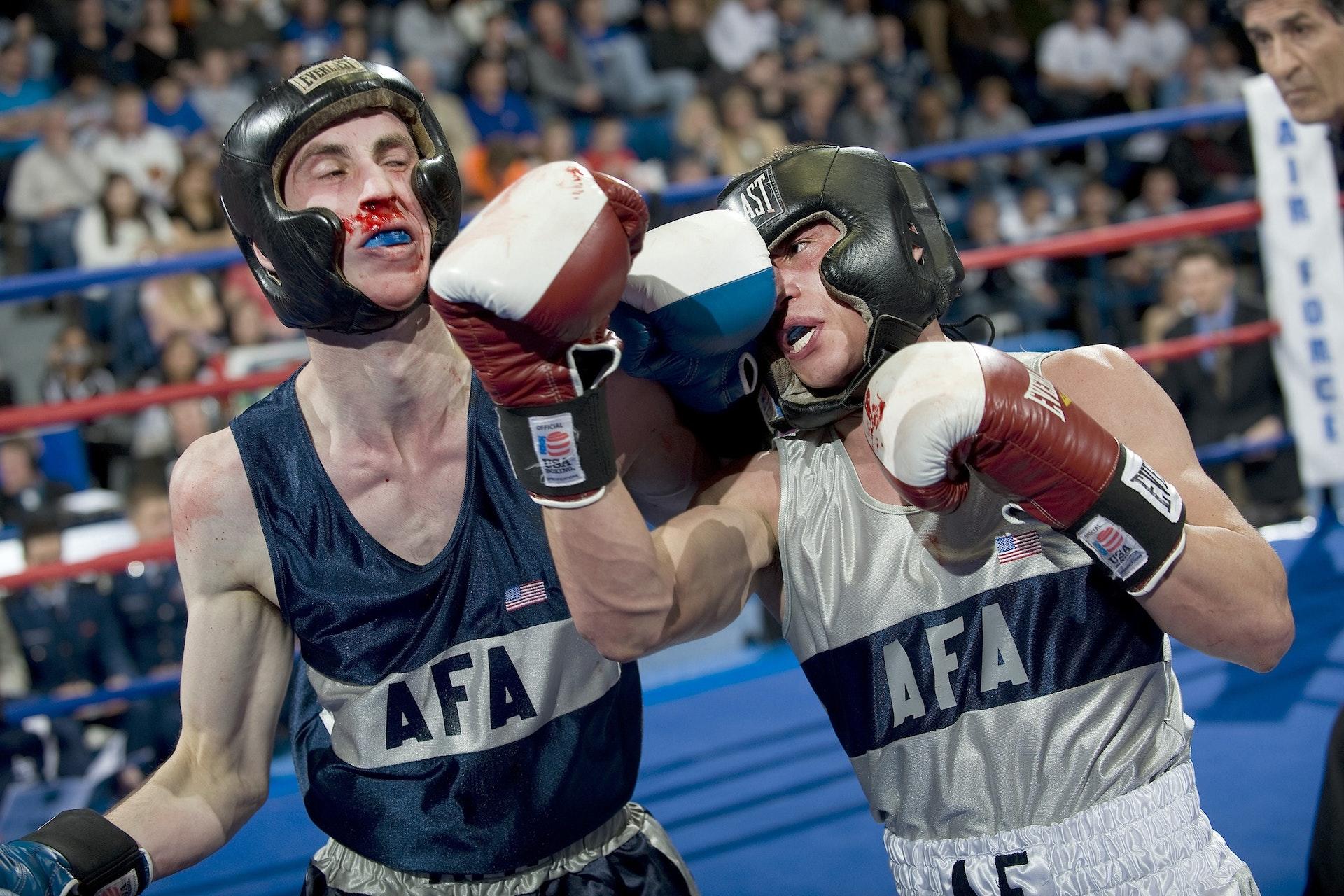Boxer in white jabbing a punch at his opponent's jaw.