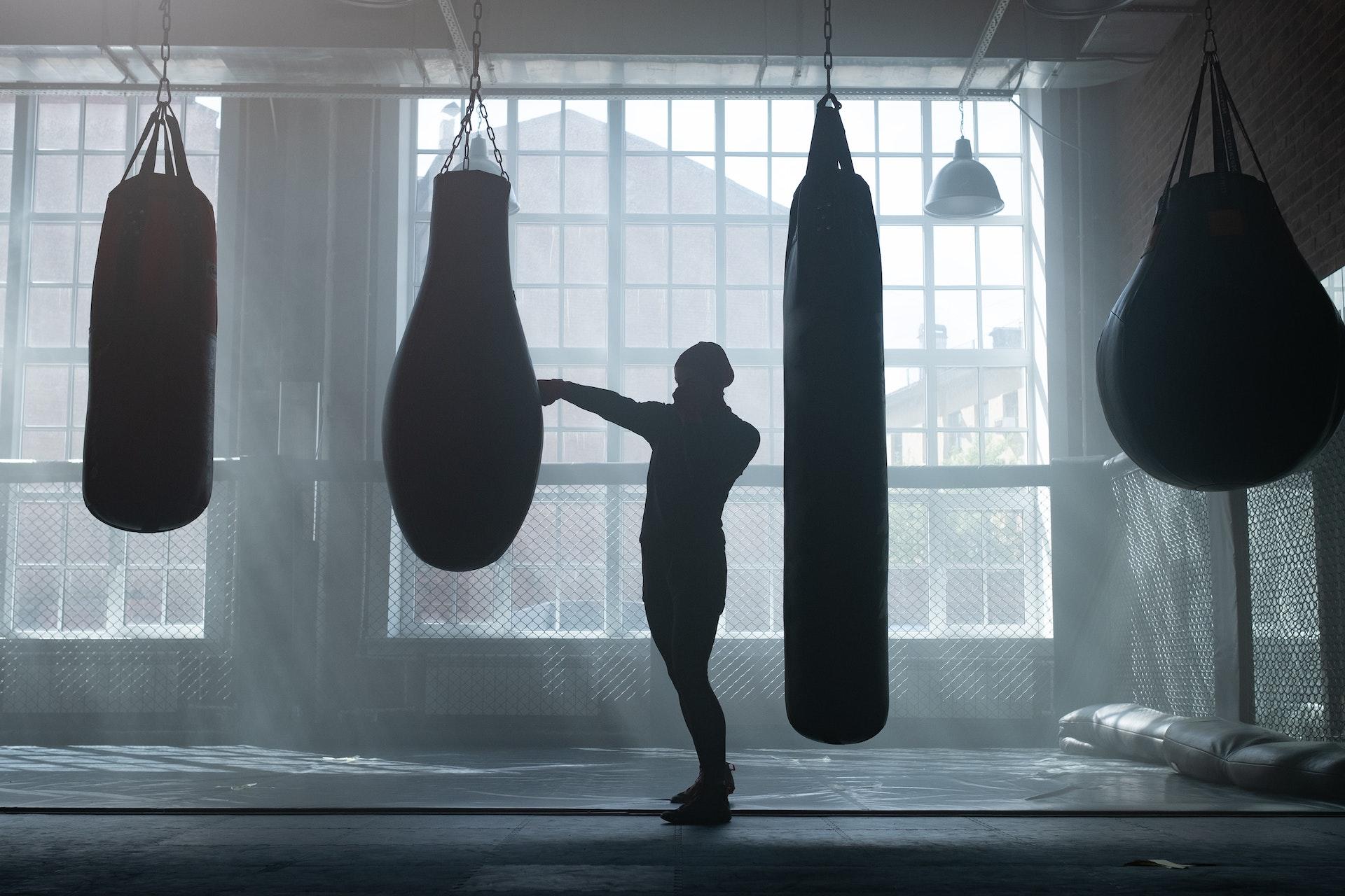 Silhouette of a boxer practicing in the gym