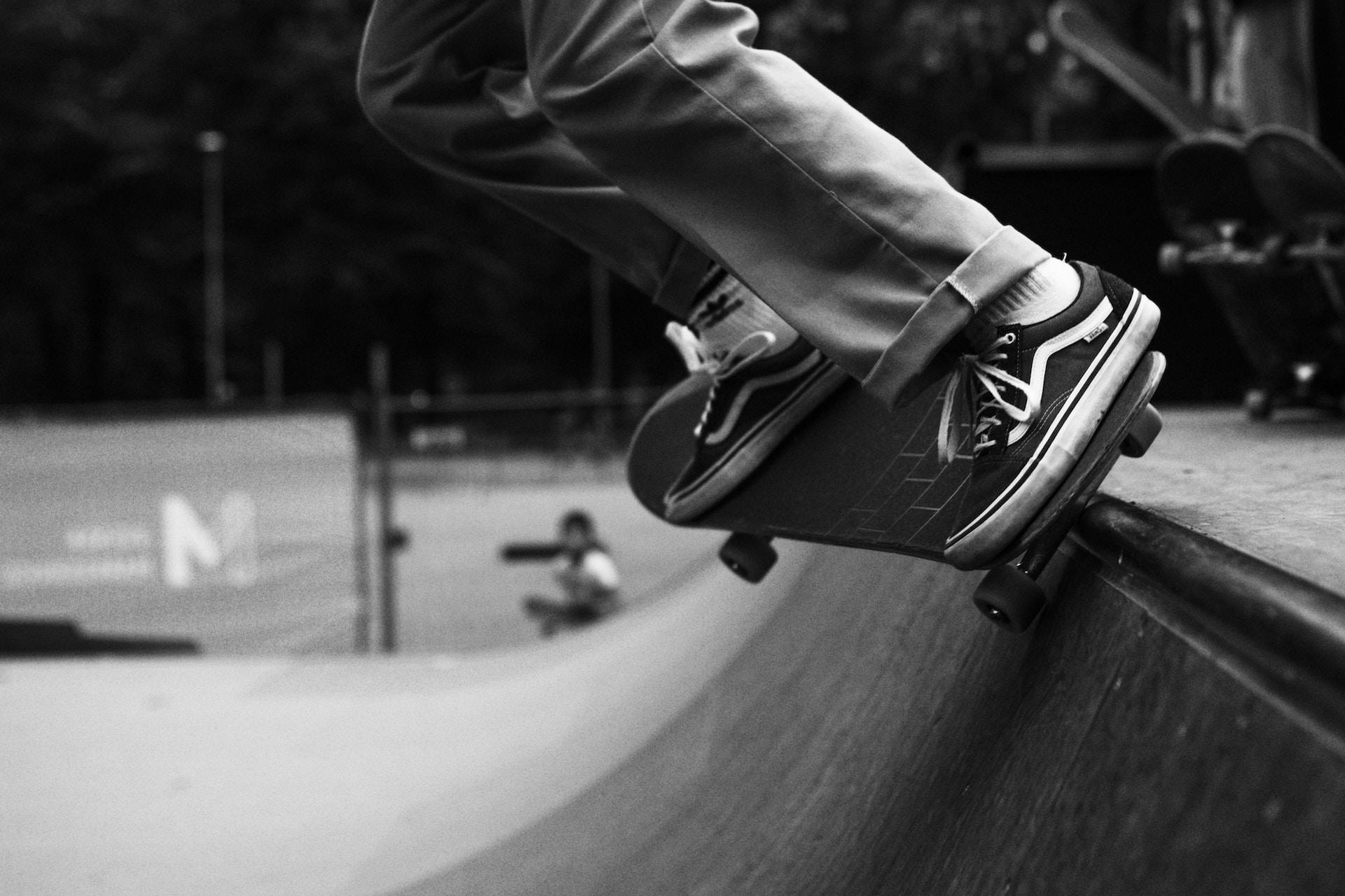 A skateboarder on the lip of a vert ramp.
