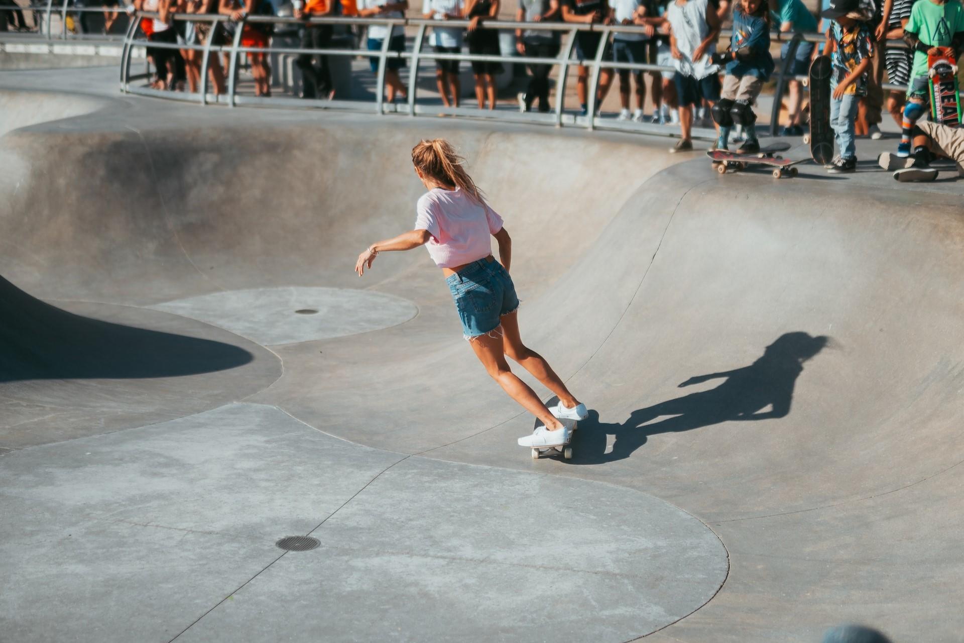 A skateboarder in a bowl at a skatepark.