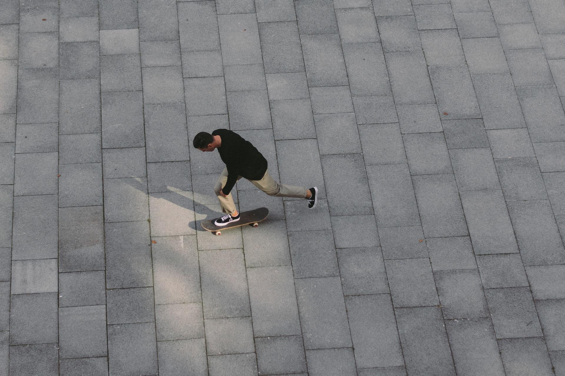 A man skateboarding in a plaza.