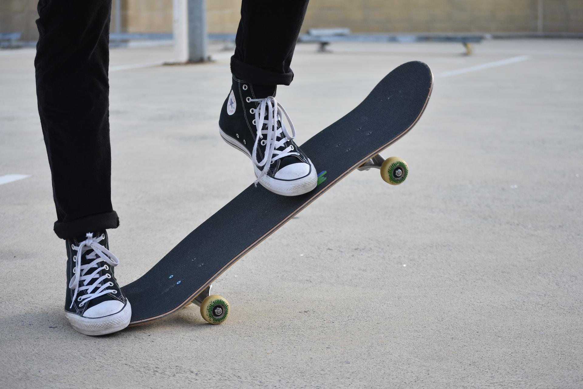 A skateboarder standing on the end of their board.