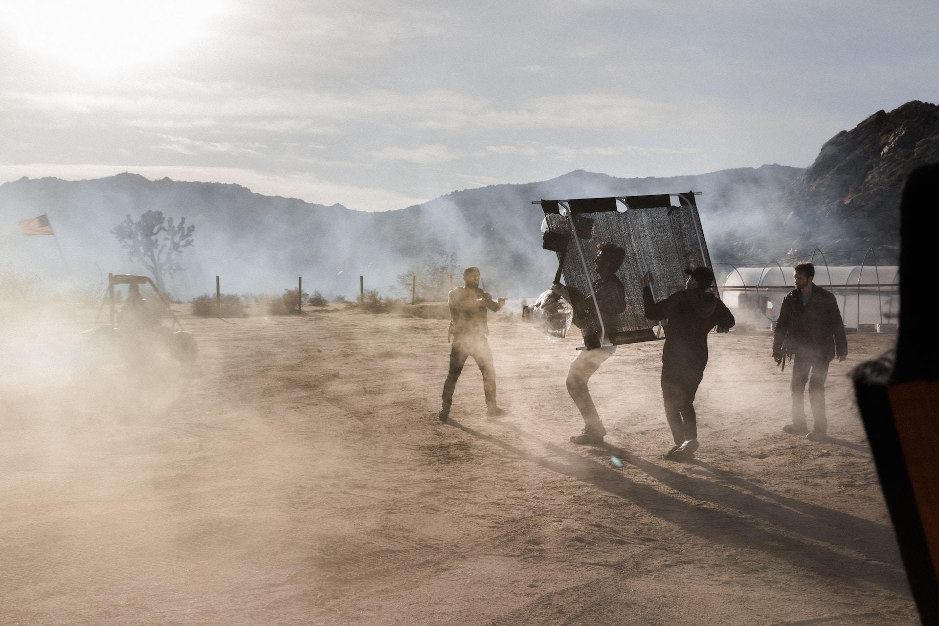 A filming location with a cameraman and an actor.