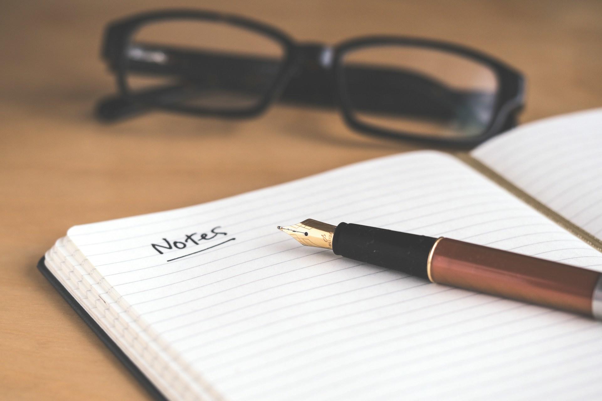 A notepad with a fountain pen on it.