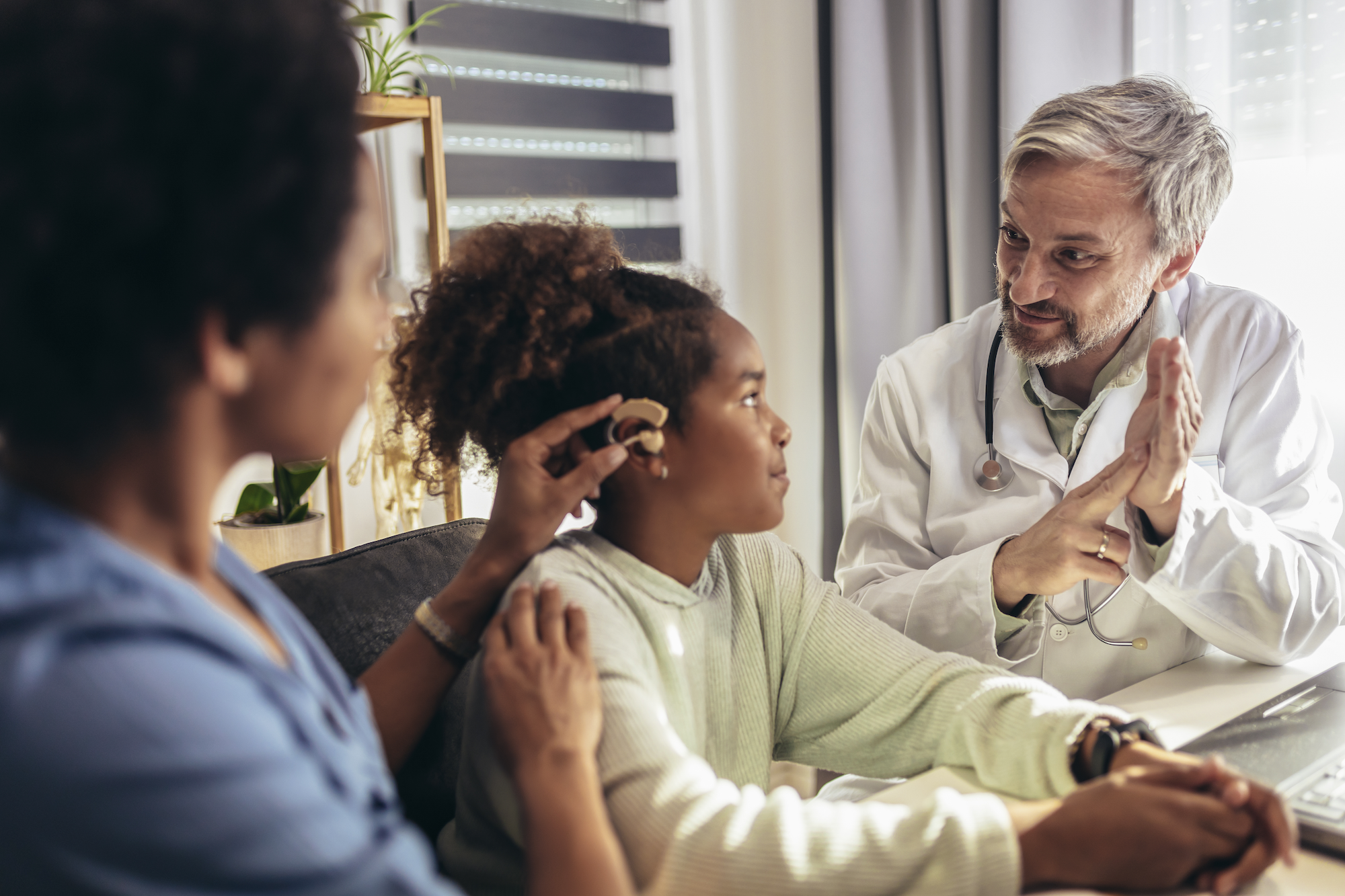 Girl receiving a hearing aid device.