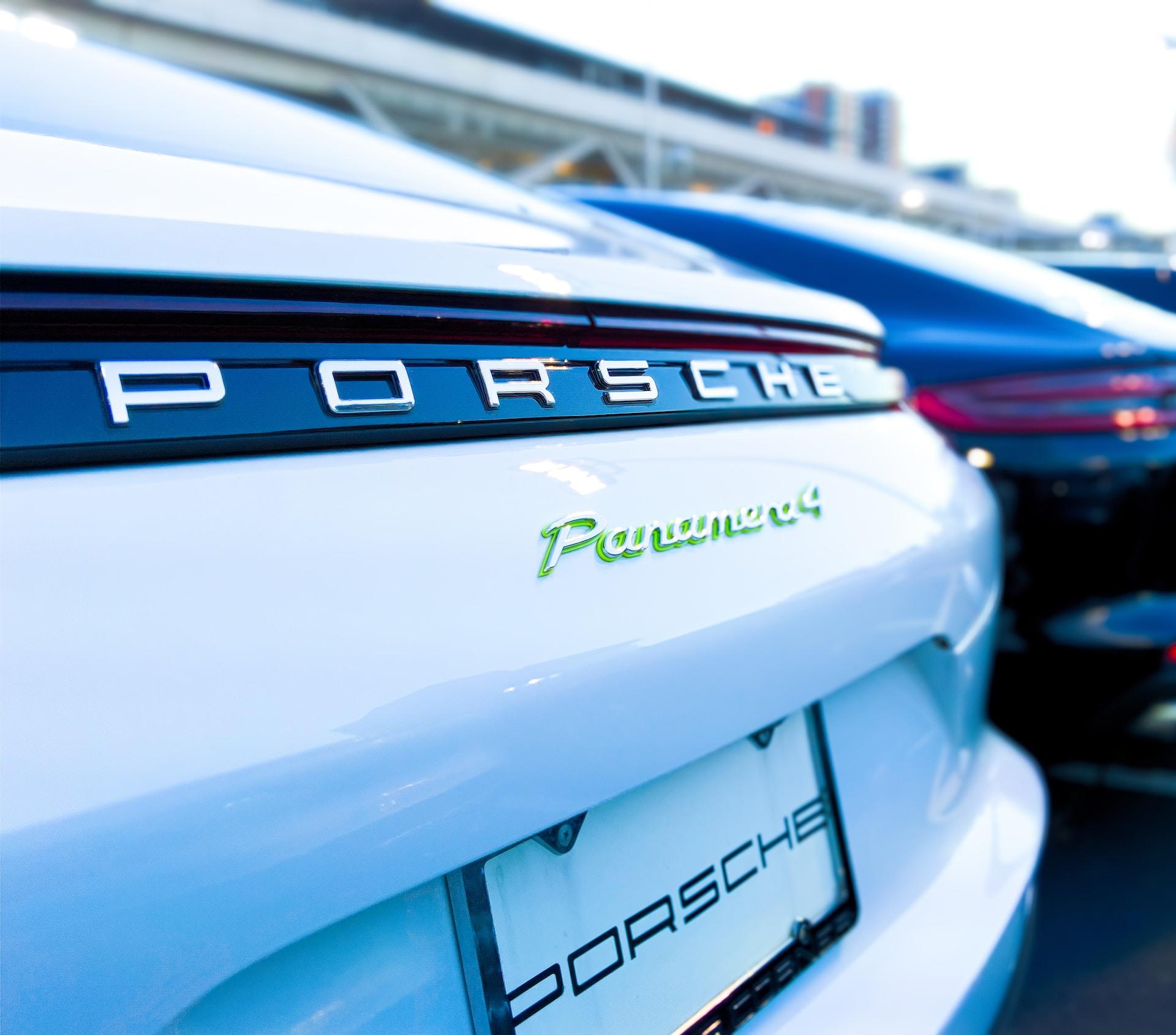 An extreme closeup of a new white Porsche's back end, with the license plate area in clear focus. 