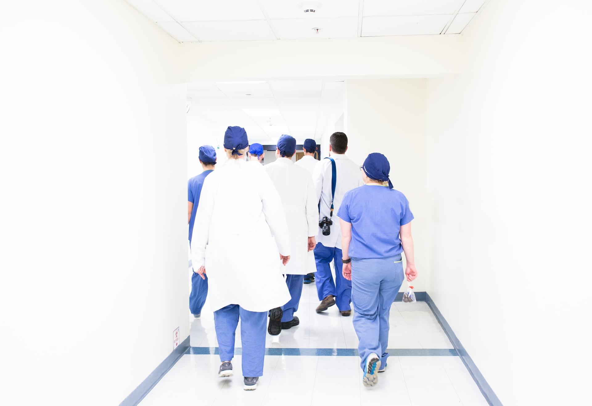 Nurses and doctors walking in a hallway.
