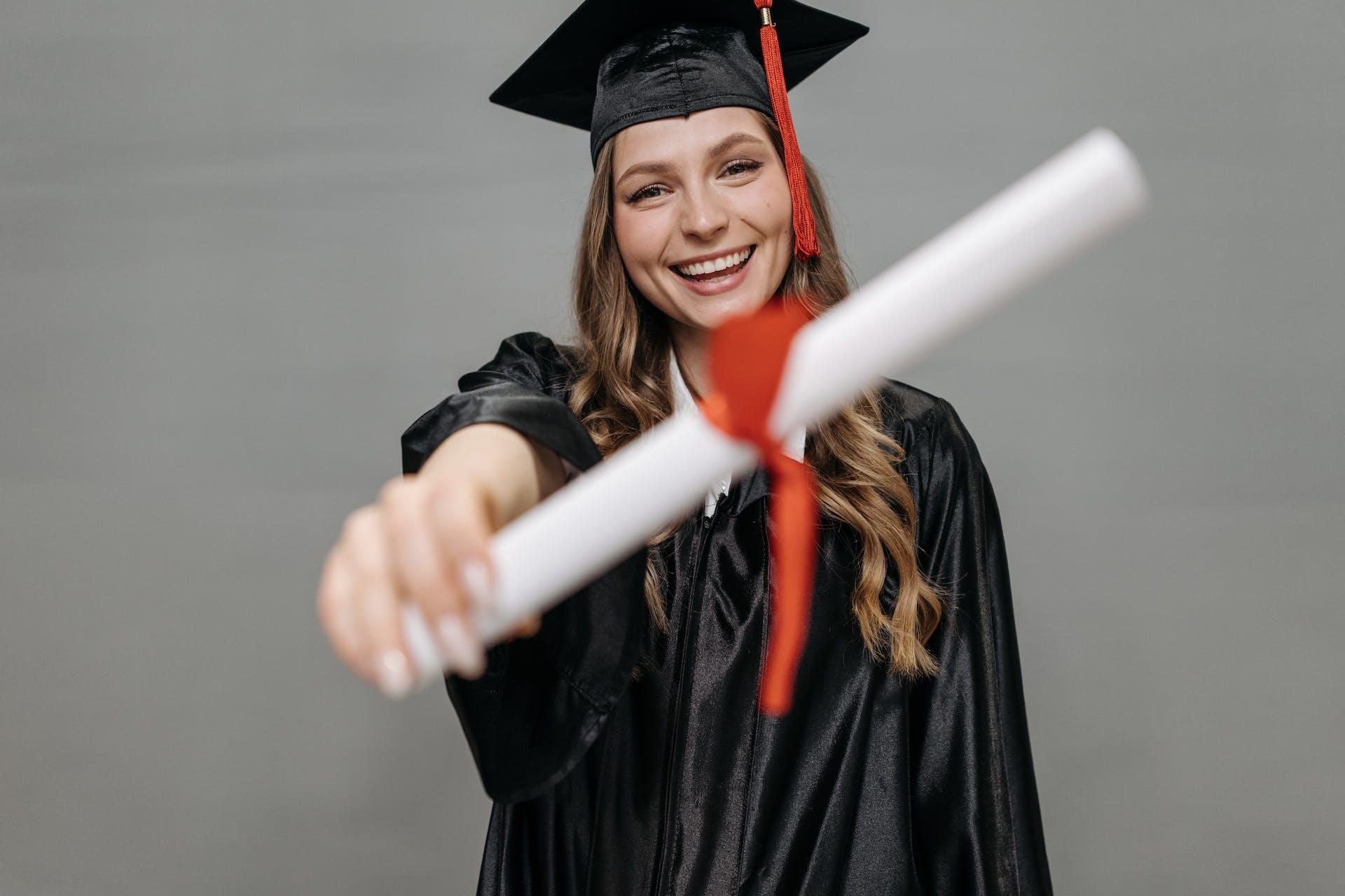 A girl in her graduation gown and hat, showing her degree.