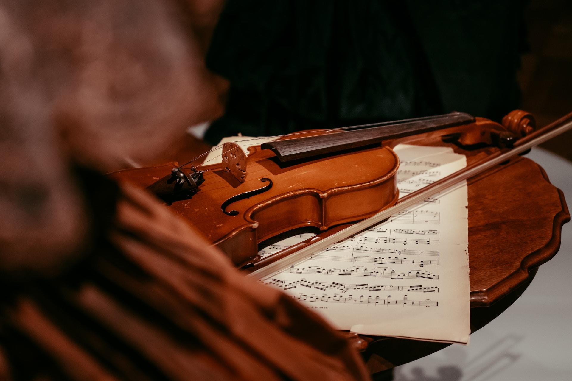 A violin on a table with sheet music.