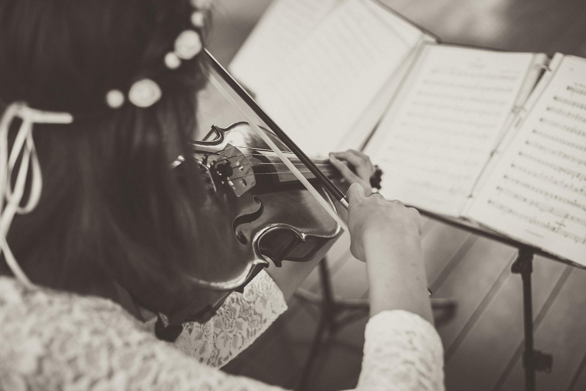 A view over the shoulder of a violinist performing.
