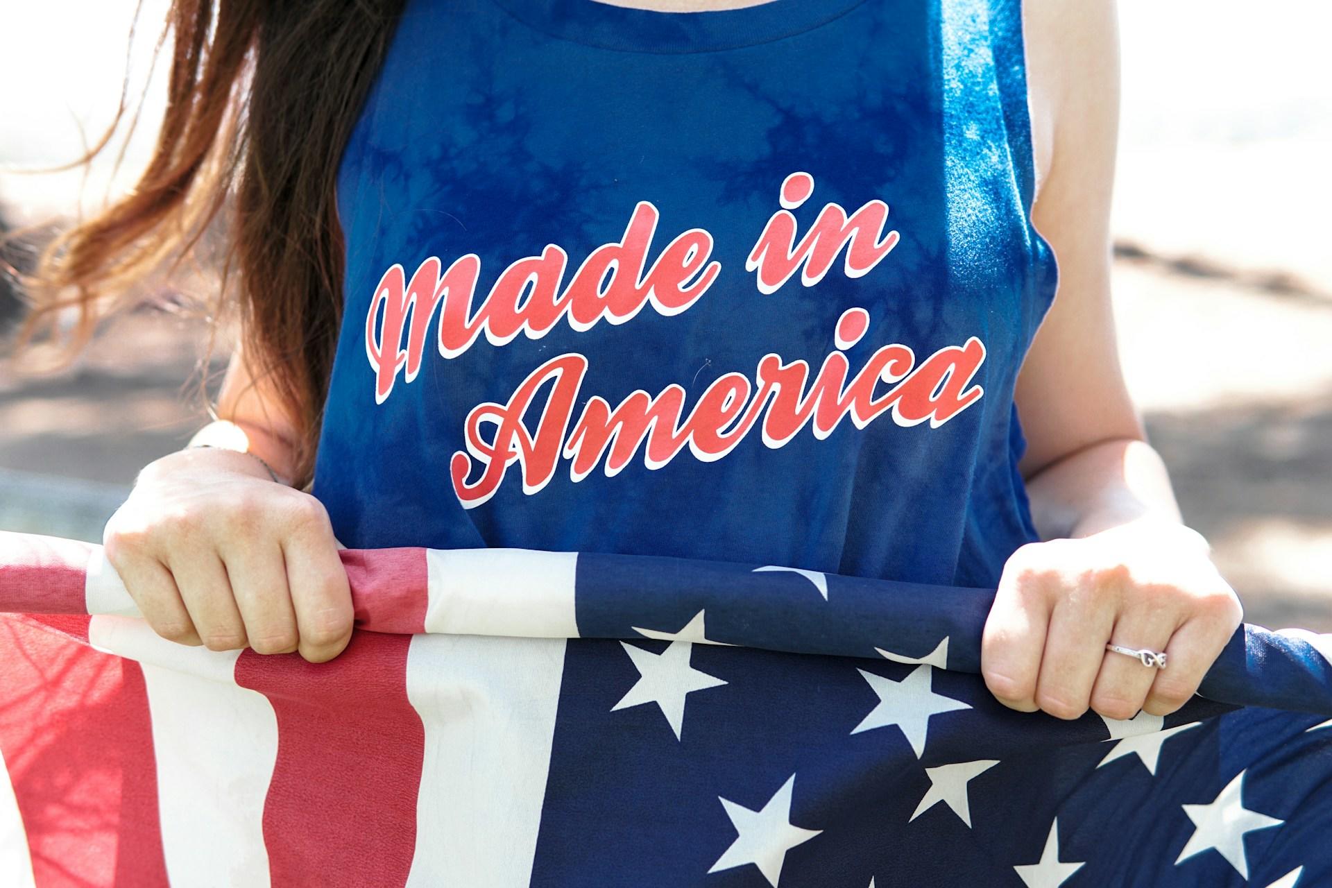 person wearing a made in america tshirt and holding an american flag