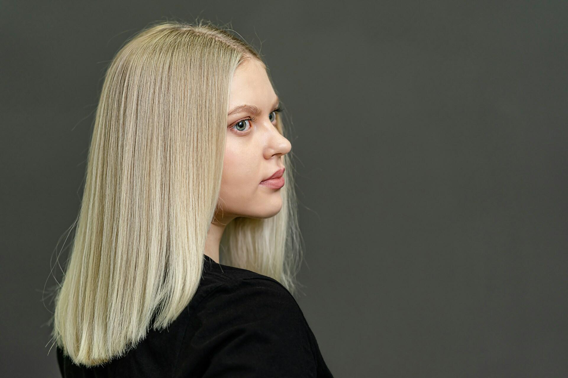 A person with blond hair wearing a black top.