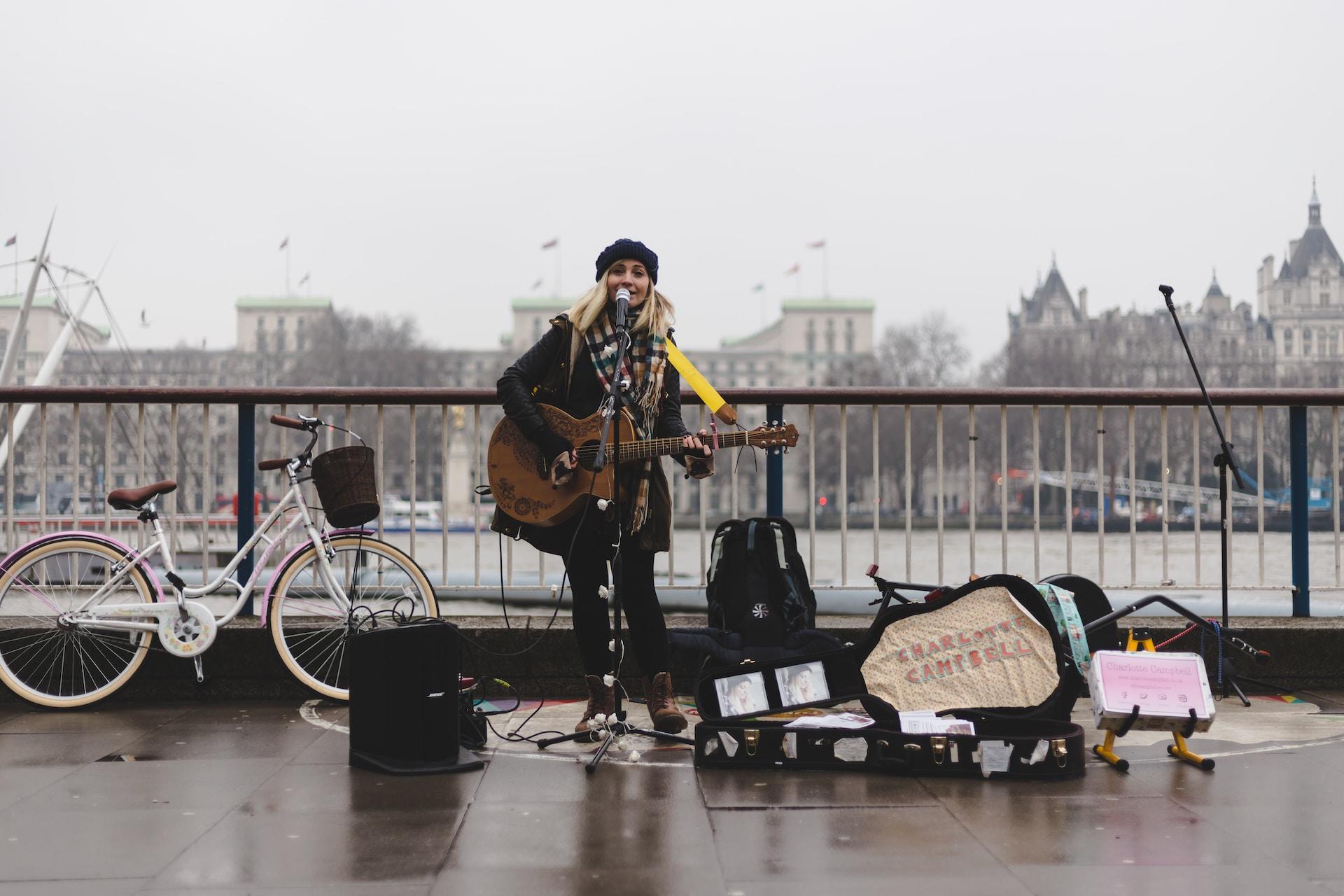 A girl playing guitar on the street, busking