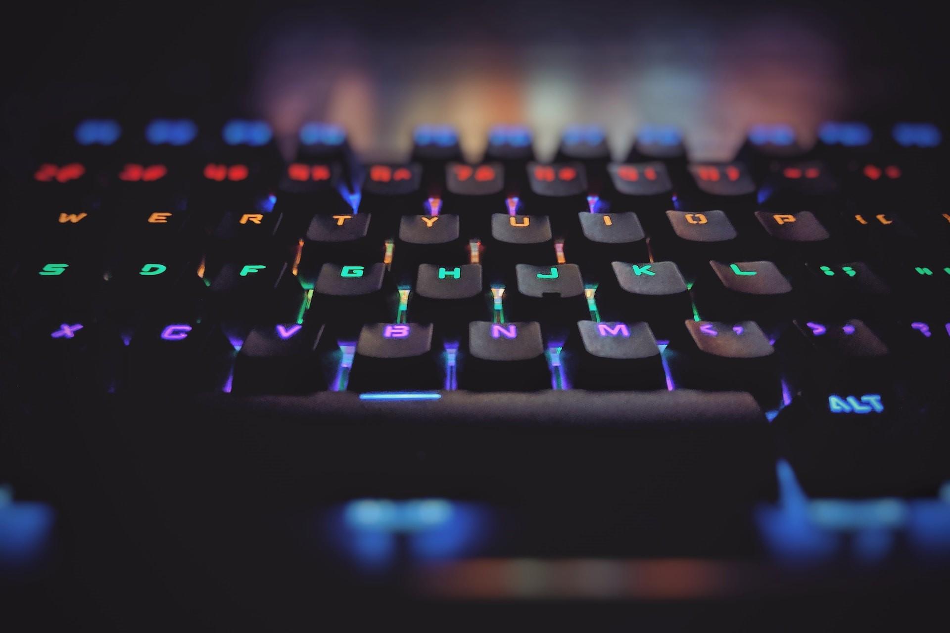 A closeup of a keyboard with colored illuminated keys.
