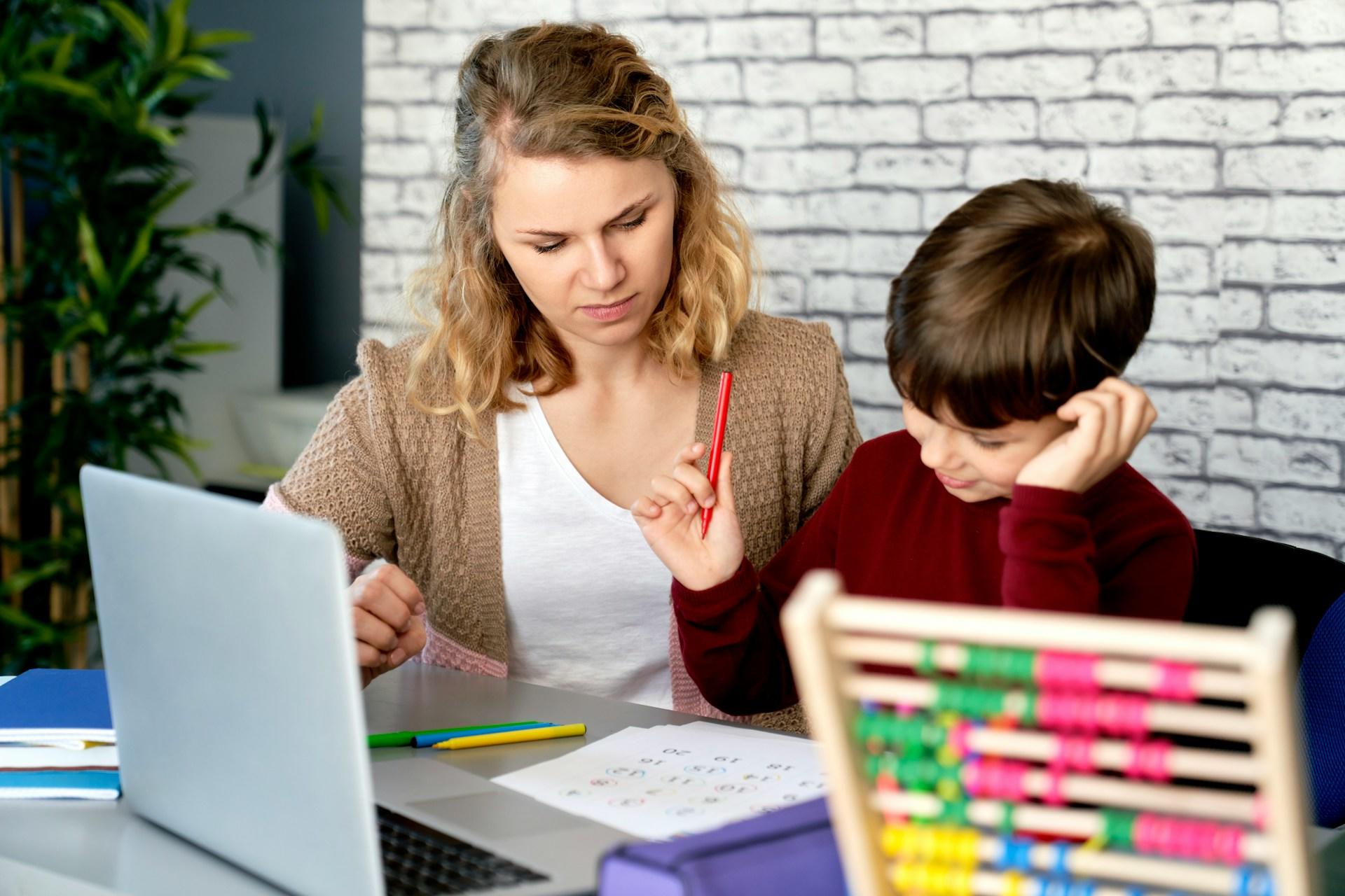 an adult and child working together on a computer with an abacus on the desk