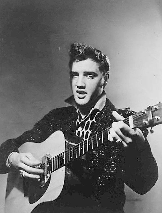 A headshot photo of Elvis with his guitar