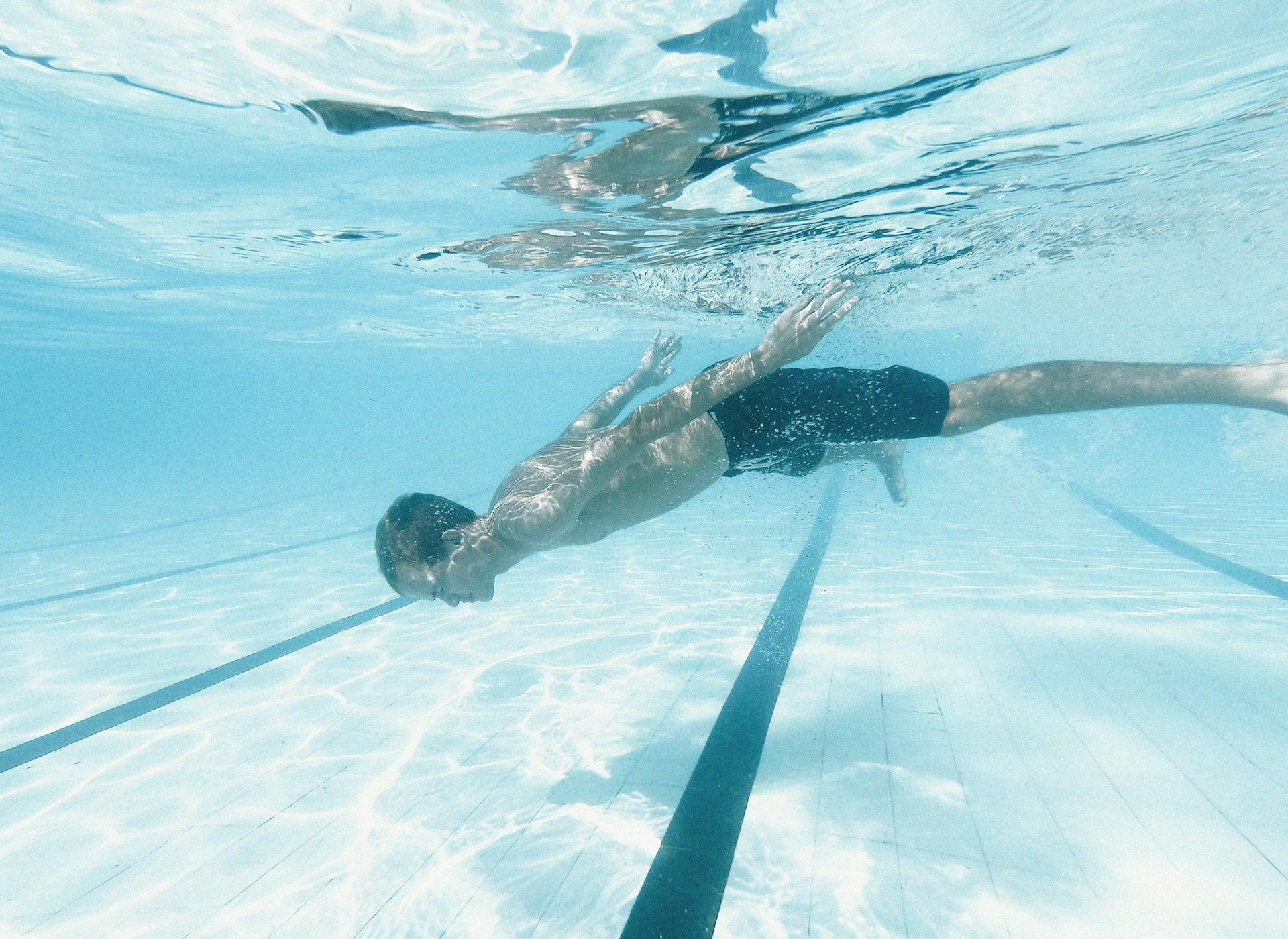 man swimming deep in water