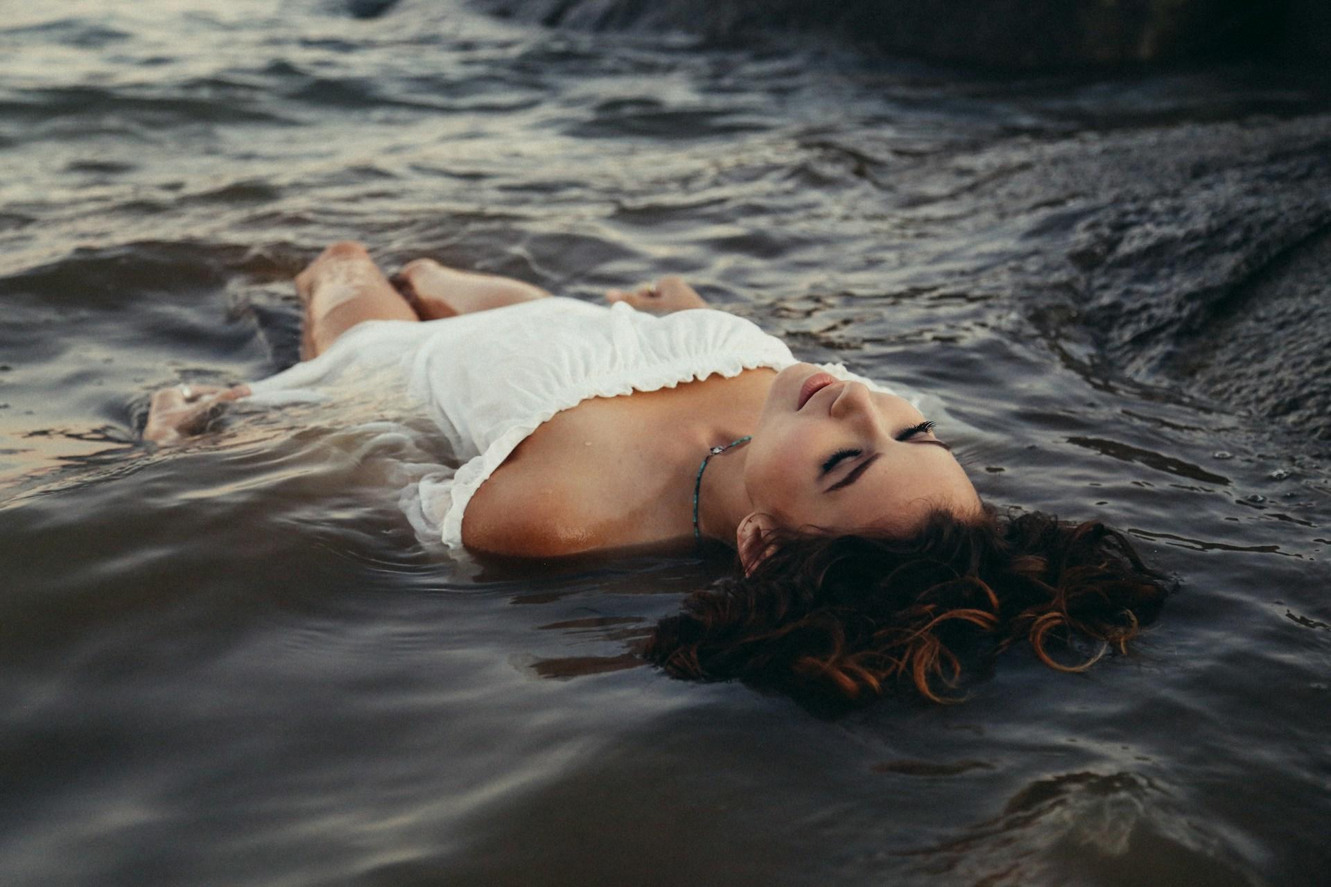 young lady laying on water
