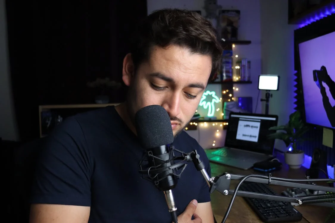 A person sitting at a desk with a professional microphone