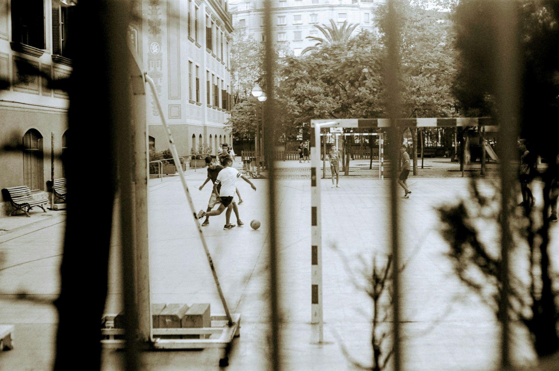 Children in Barcelona playing soccer in the street.