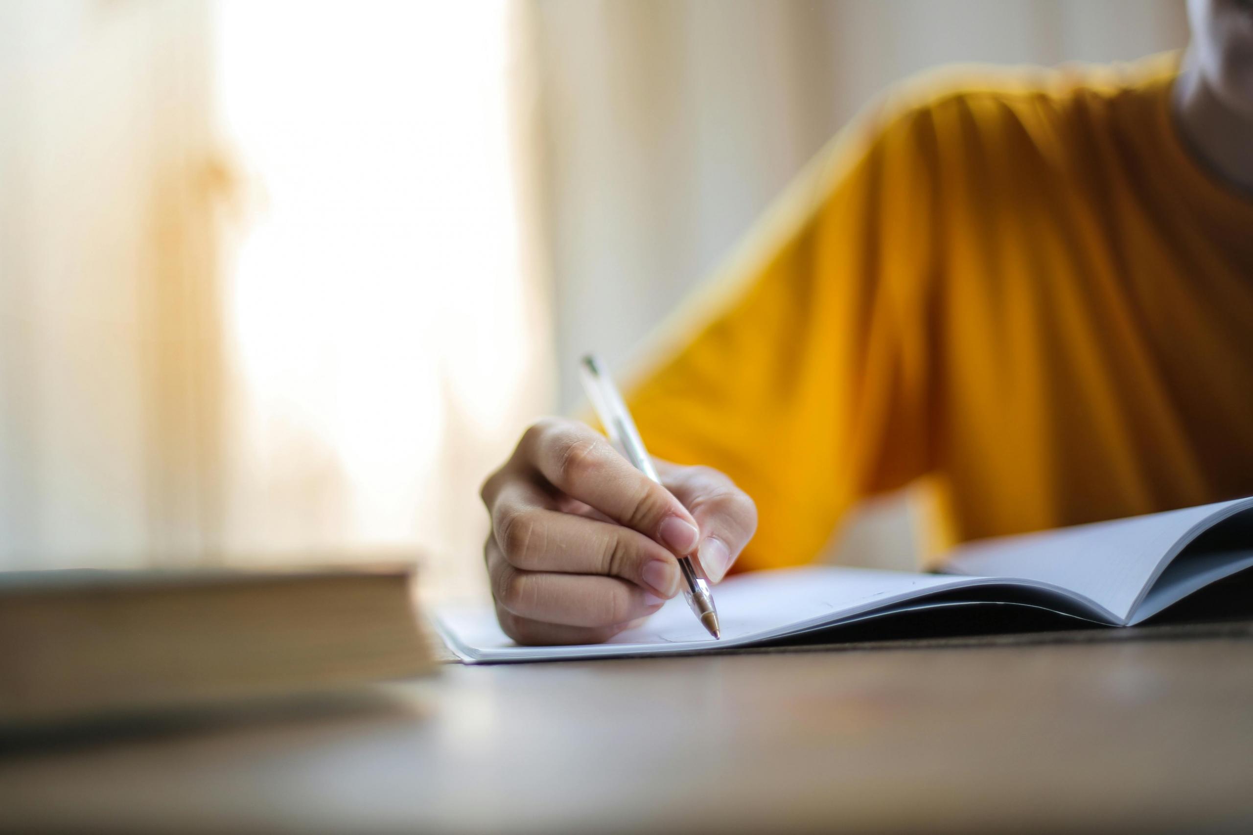 a student writes in a notebook.