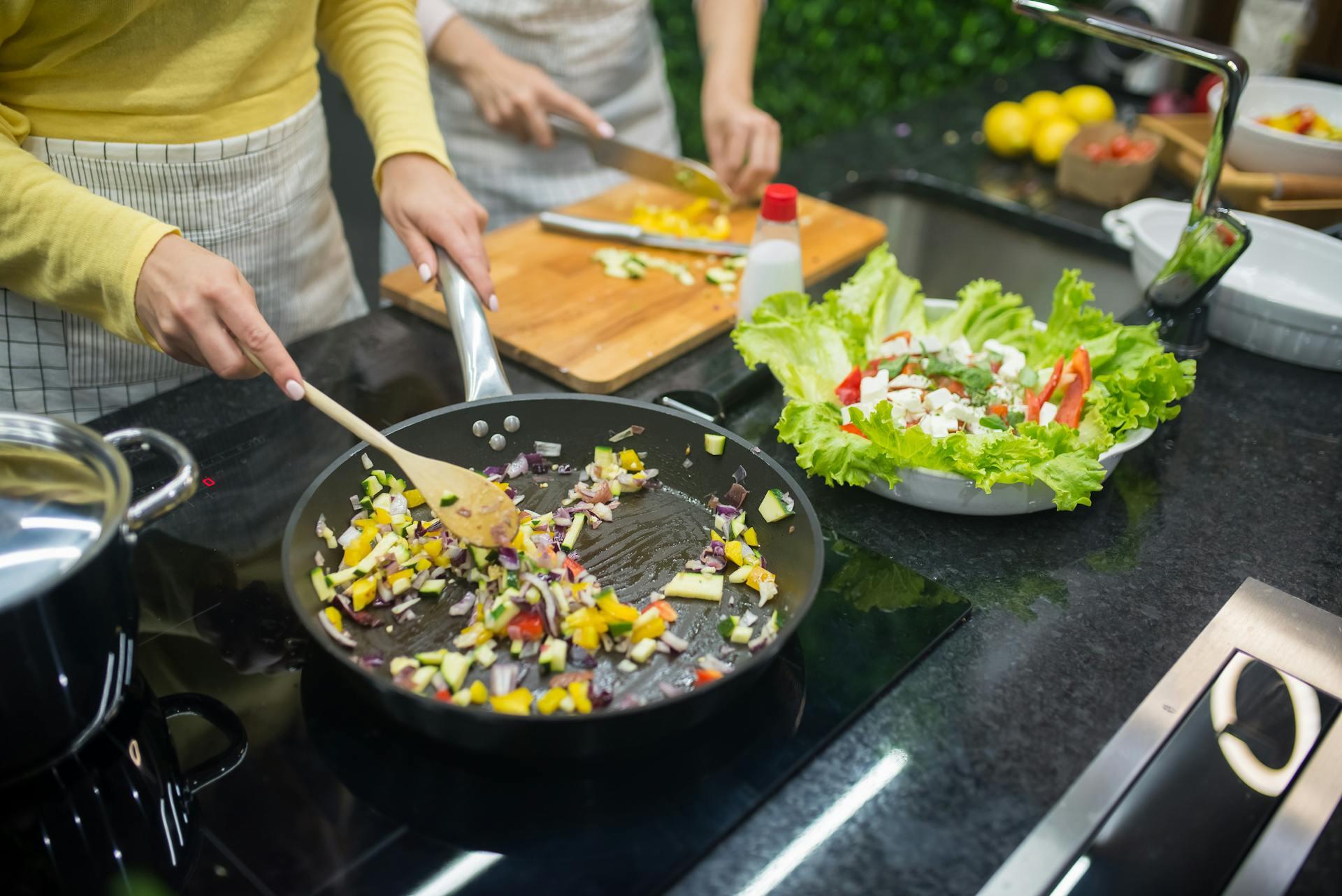a woman cooking some vegetables
